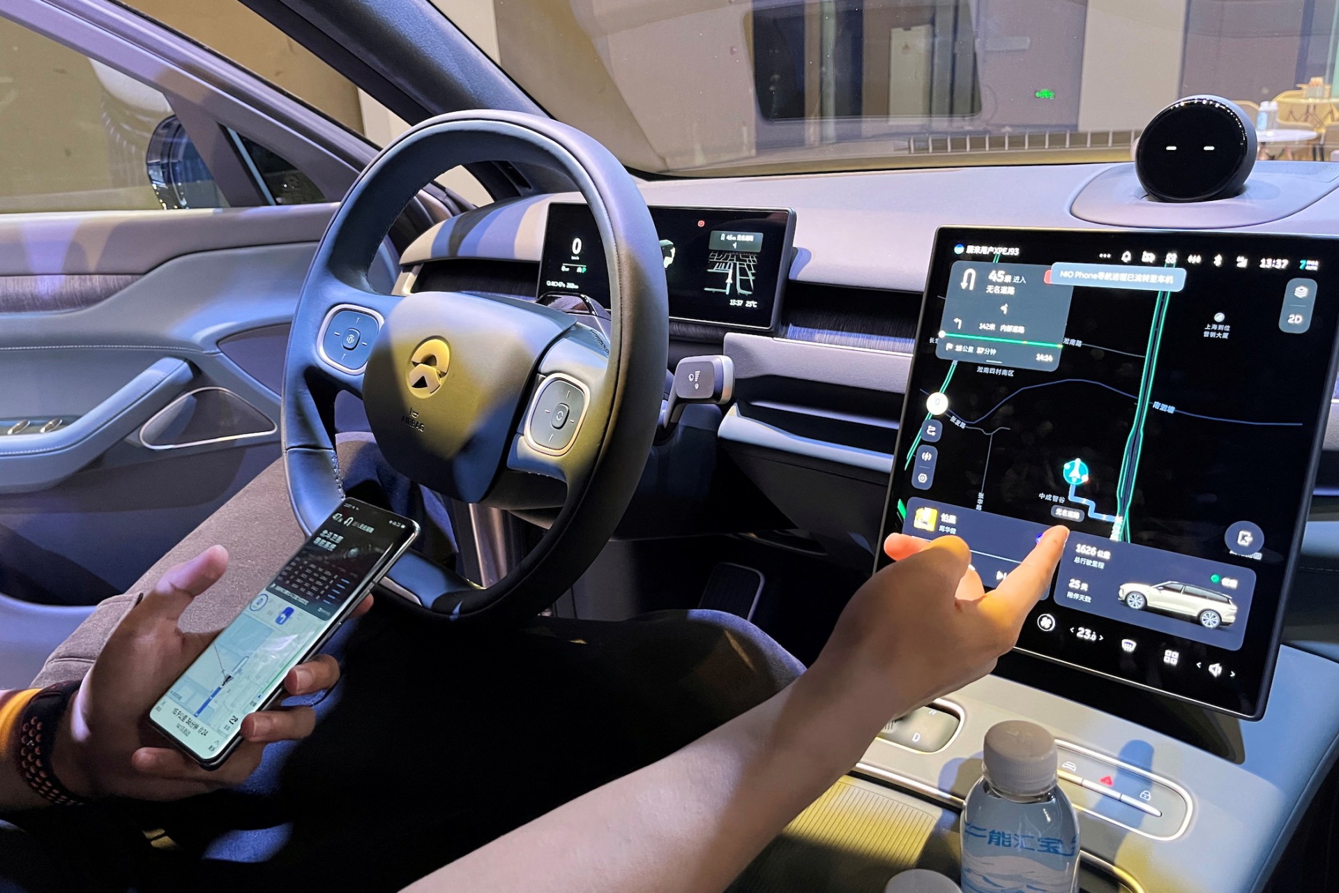 <p>A staff member of the Chinese electric vehicle maker Nio demonstrates to media members a phone’s connectivity to a car during an expo in Shanghai, China.</p>