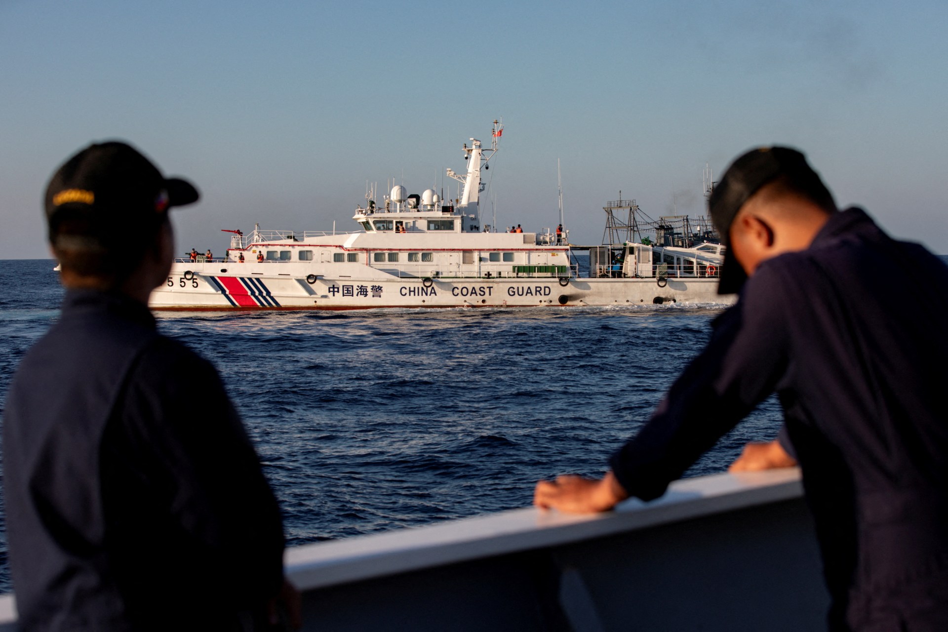<p>Members of the Philippine Coast Guard stand alert as a Chinese Coast Guard vessel blocks their way to a resupply mission at Second Thomas Shoal in the South China Sea, March 5, 2024.</p>
