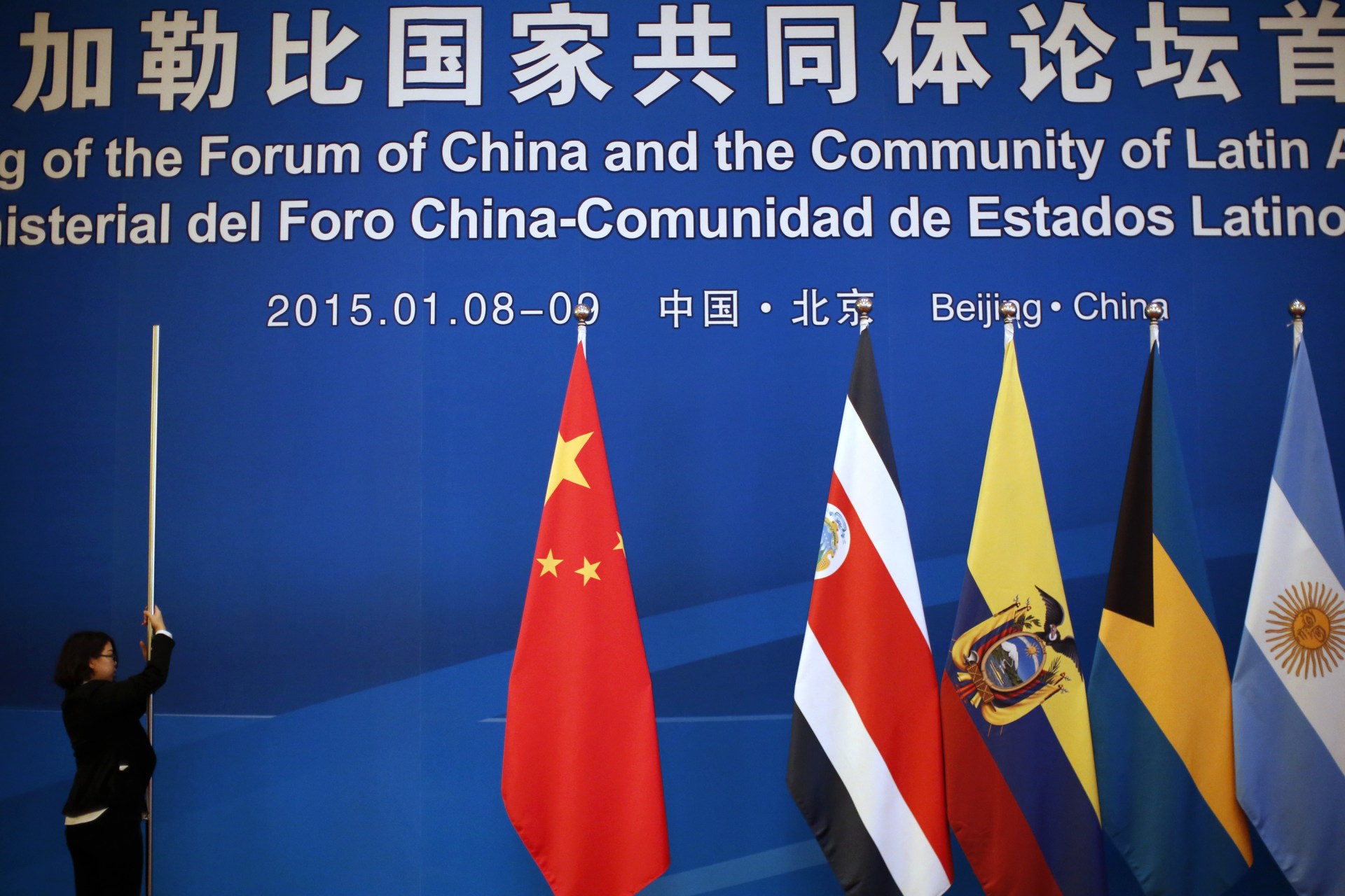 <p>A woman dismantles flags after a meeting at the1st Ministerial Meeting of the China-CELAC Forum at Diaoyutai State Guesthouse in Beijing January 9, 2015.</p>
