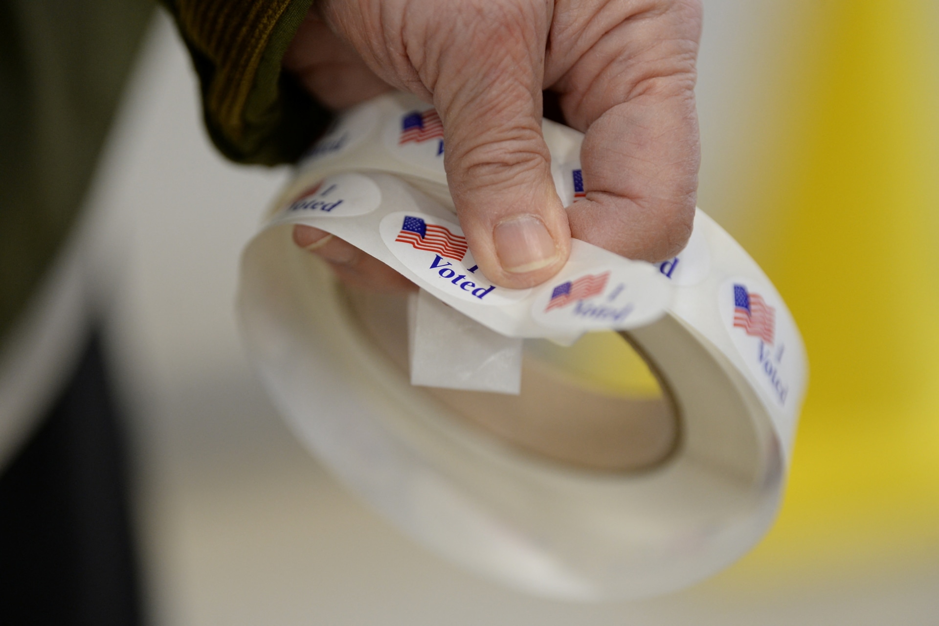 <p>A poll worker holds voting stickers during a U.S. election.</p>
