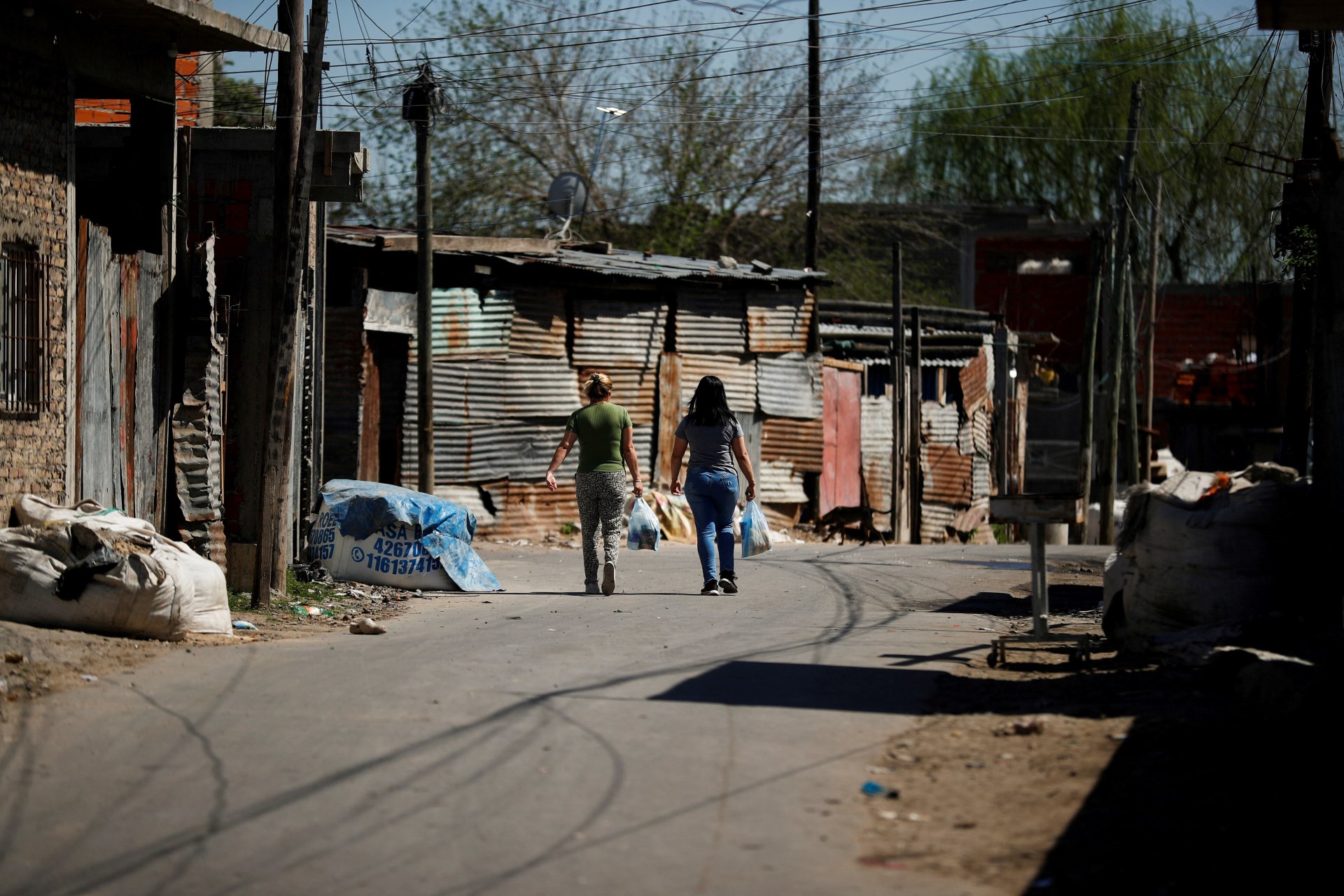 <p>Women carry shopping bags while walking in the working-class neighbourhood Villa Fiorito, in Buenos Aires, Argentina October 9, 2023.</p>