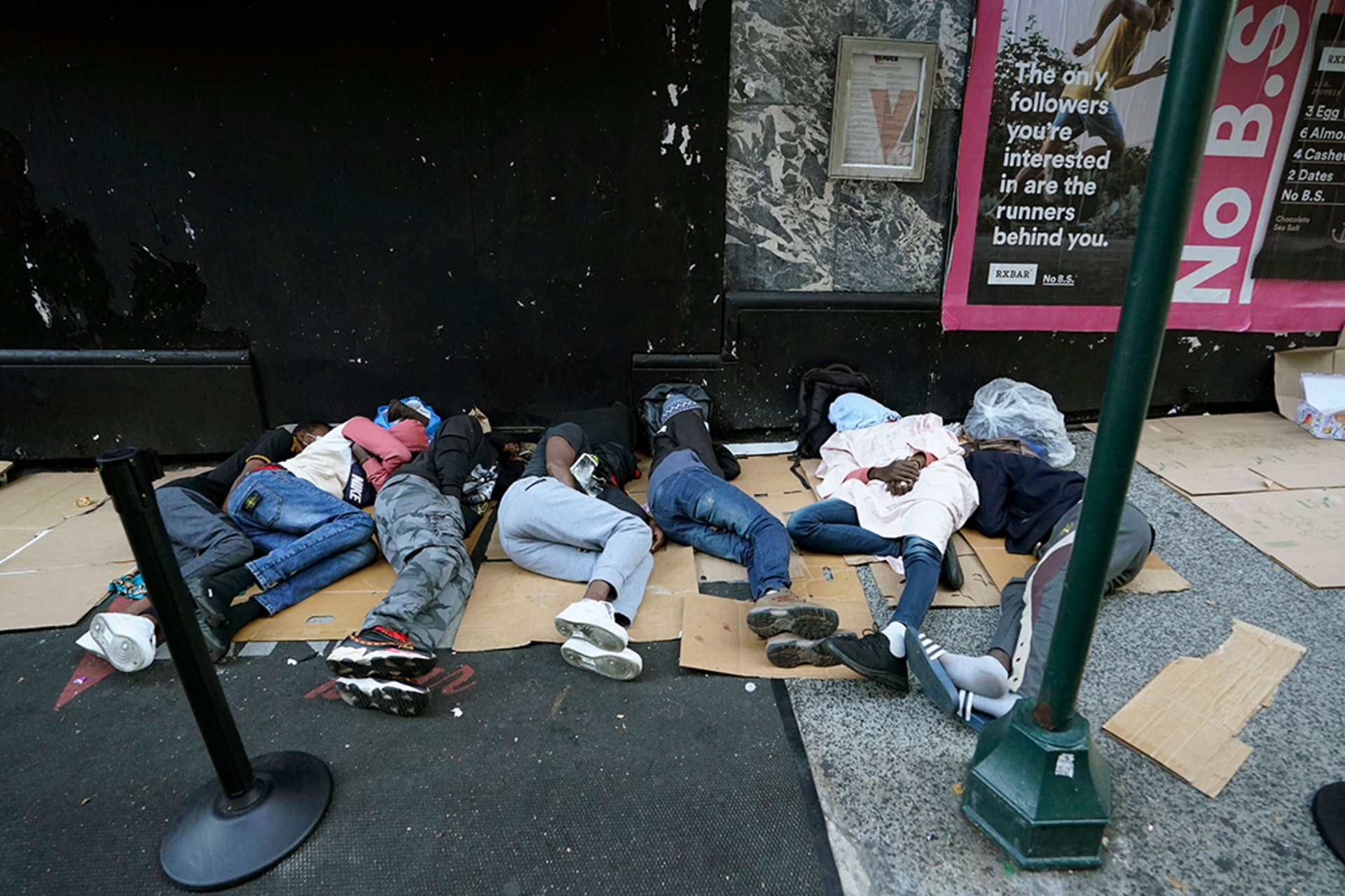 <p>Migrants sleep outside the Roosevelt Hotel in New York as they wait for housing.</p>