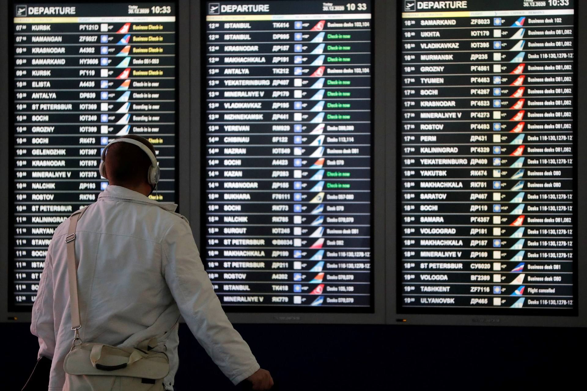 <p>A man looks at a flight information board at the departure zone of Vnukovo International Airport in Moscow, Russia on December 30, 2020.</p>