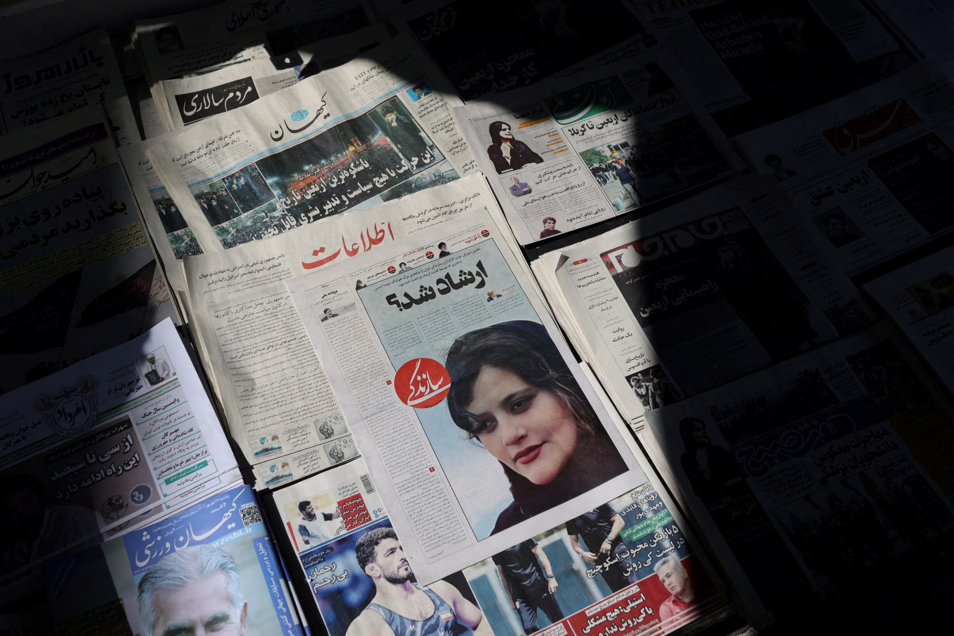<p>A newspaper with a cover picture of Mahsa Amini, a woman who died after being arrested by the Islamic republic’s “morality police” is seen in Tehran, Iran September 18, 2022.</p>