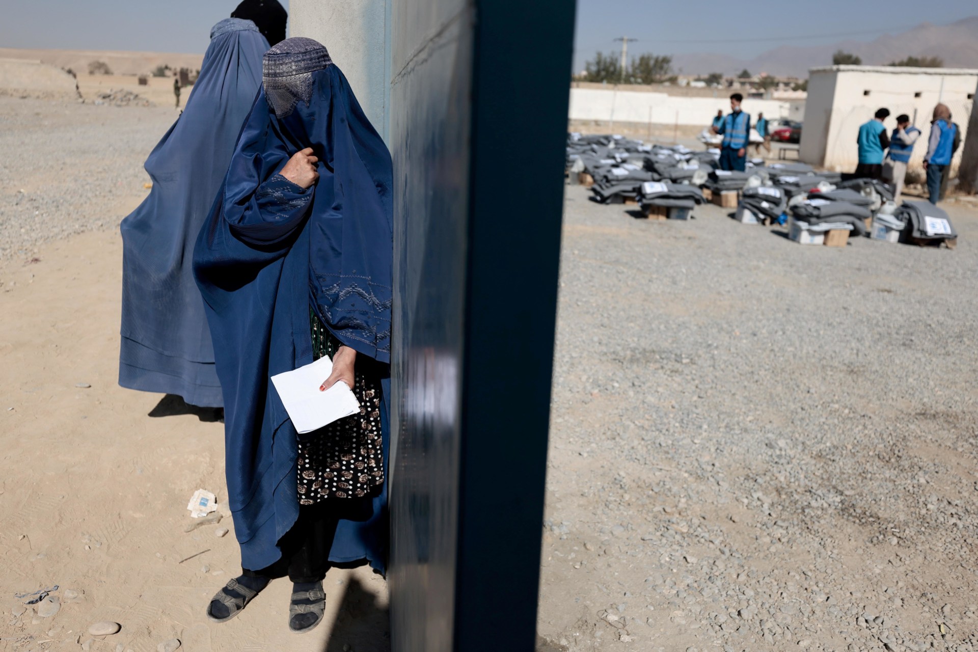 <p>A displaced Afghan woman waits to receive aid supply from UNCHR agency outside a distribution center on the outskirts of Kabul, Afghanistan October 28, 2021.</p>