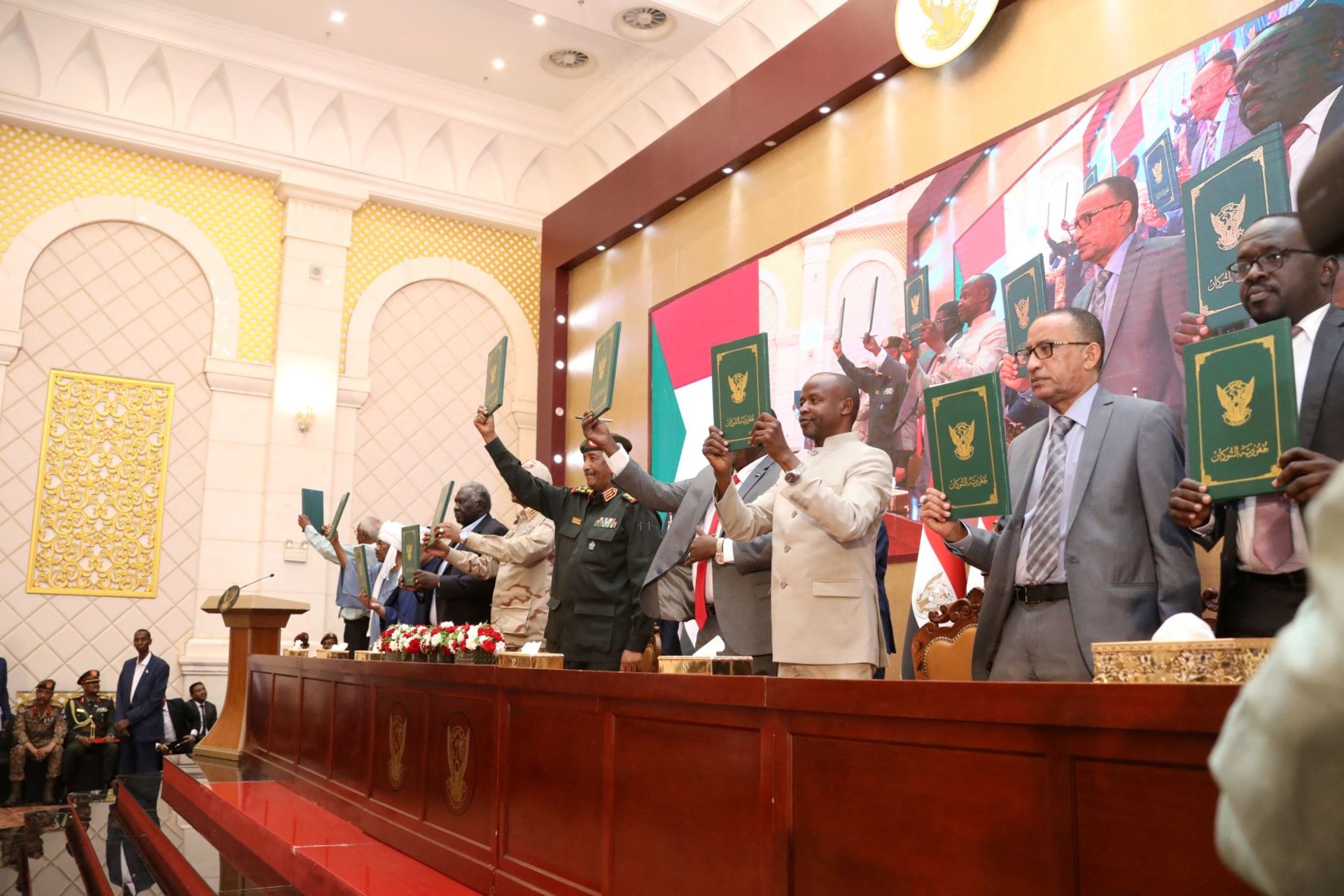 <p>Signatory parties stand and raise signed copies of the agreement between military rulers and civilian powers in Khartoum, Sudan on December 5, 2022.</p>
