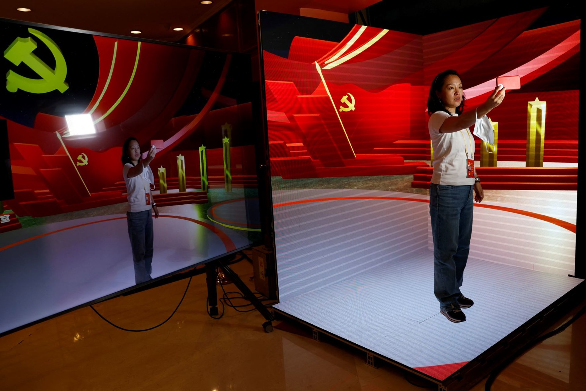 <p>A woman poses for pictures at a digital media demonstration zone inside a media hotel for journalists covering the 20th National Congress of the Communist Party of China, in Beijing, China, October 19, 2022.</p>
