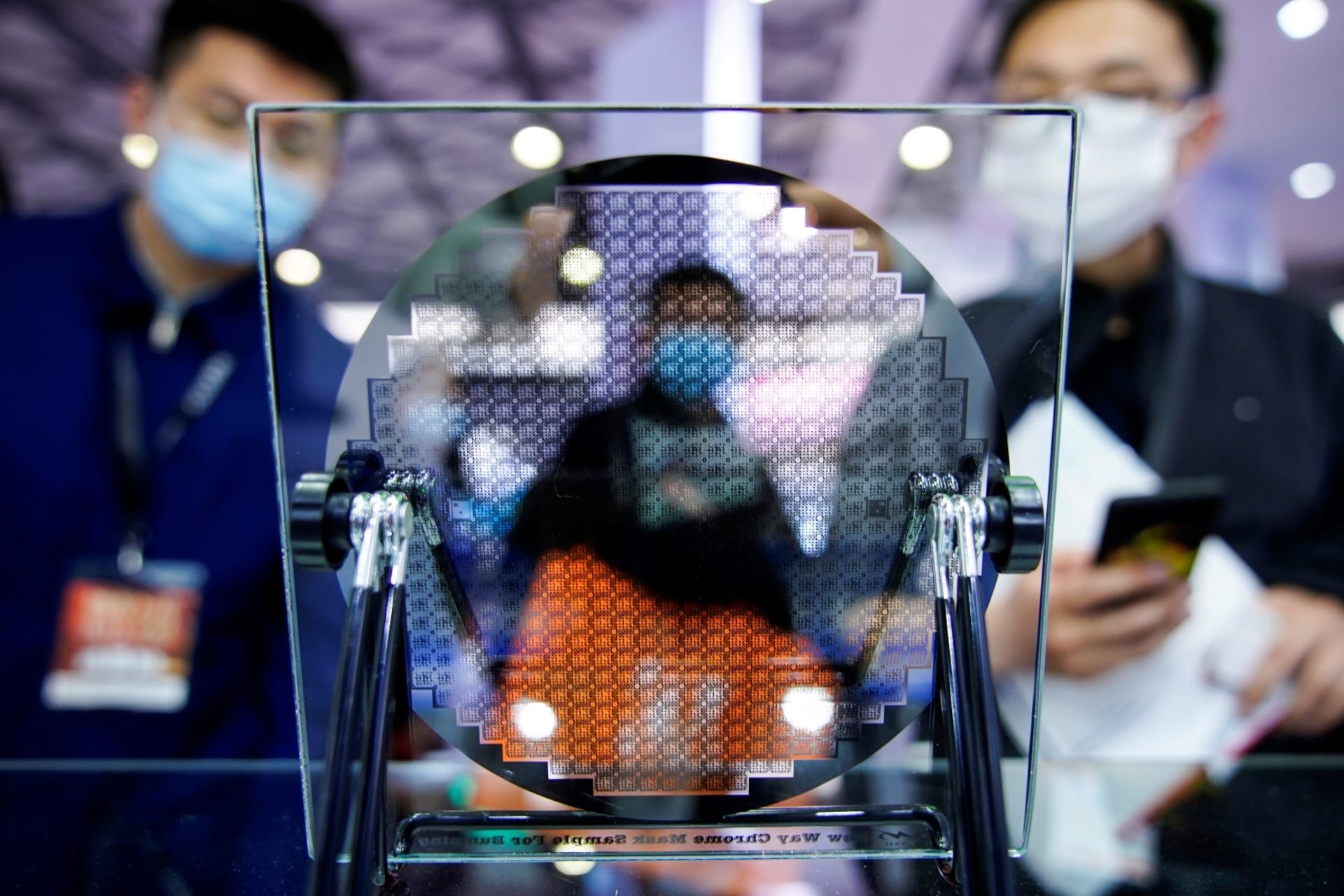 <p>Visitors look at a display of a semiconductor device at Semicon China, a trade fair for semiconductor technology, in Shanghai, China.</p>