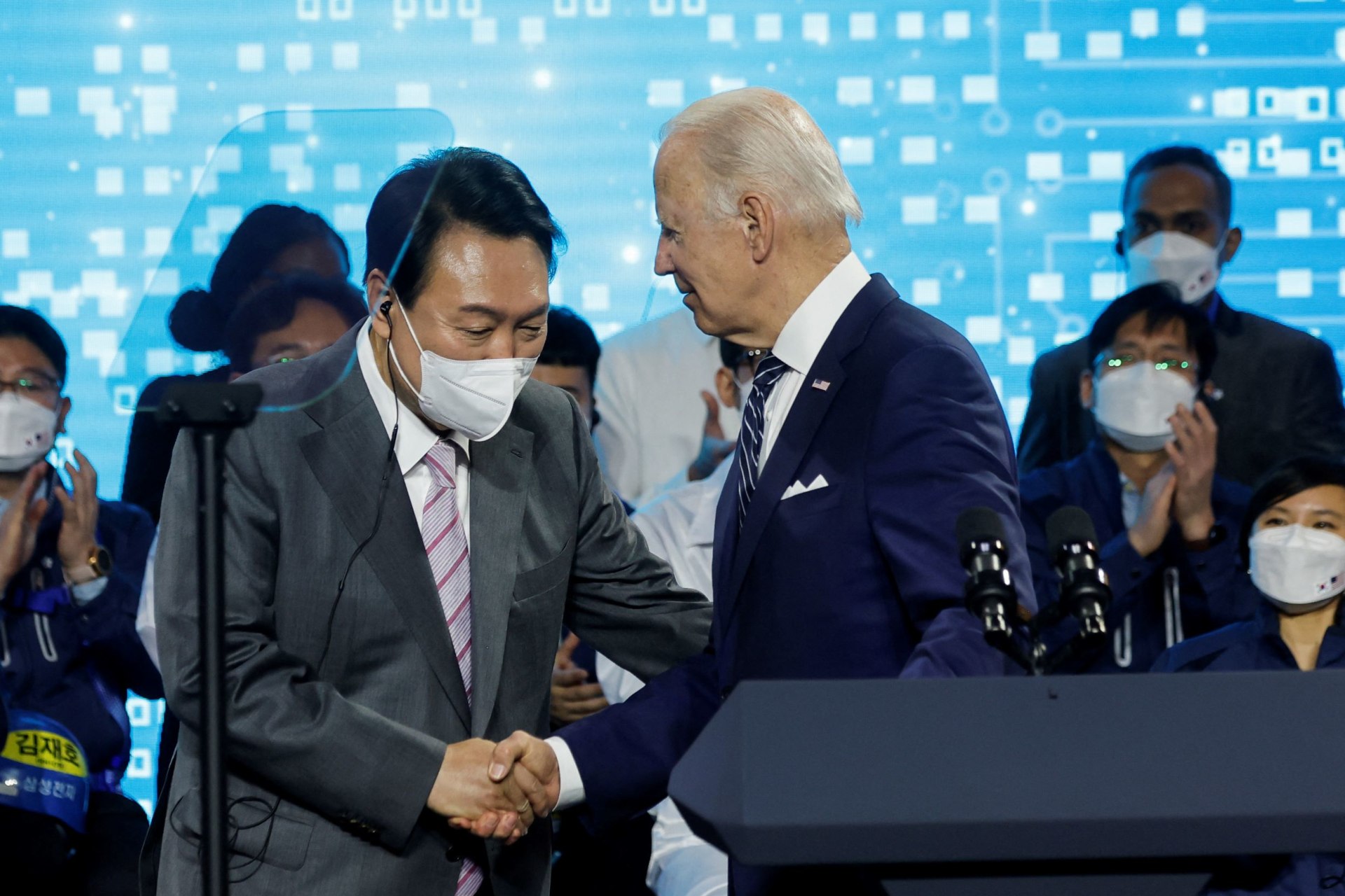 <p>U.S. President Joe Biden shakes hands with South Korean President Yoon Suk-yeol after delivering remarks during a visit to a semiconductor factory at the Samsung Electronics Pyeongtaek Campus in Pyeongtaek, South Korea on May 20, 2022.</p>
