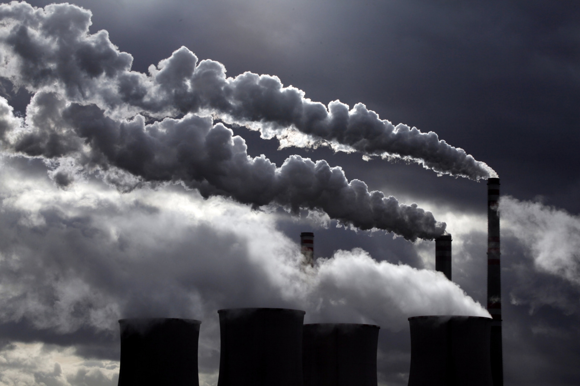 <p>Cooling towers and smoke stacks at a power plant. </p>