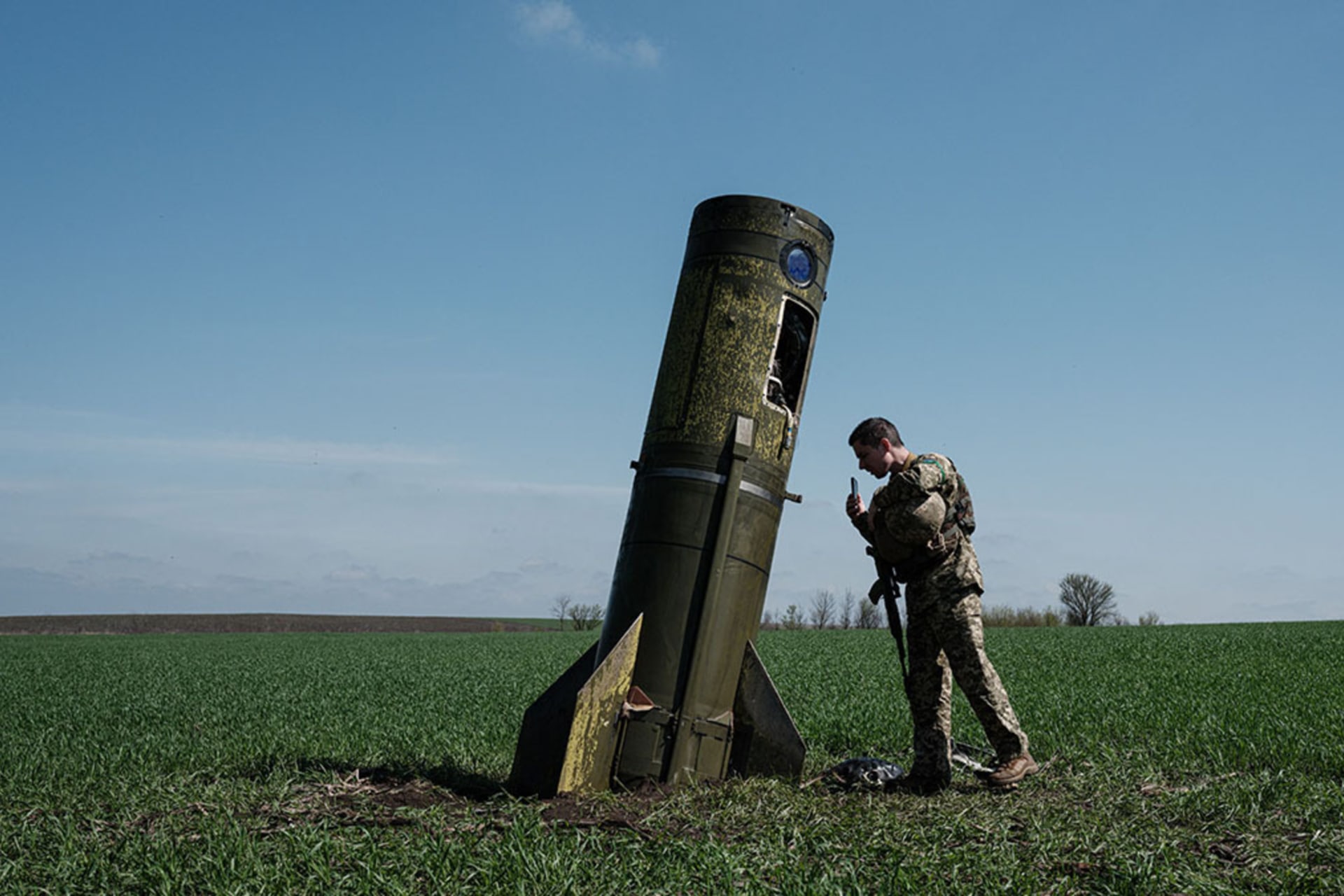 <p>A Ukrainian serviceman looks at a Russian ballistic missile booster that fell in a field in eastern Ukraine.</p>