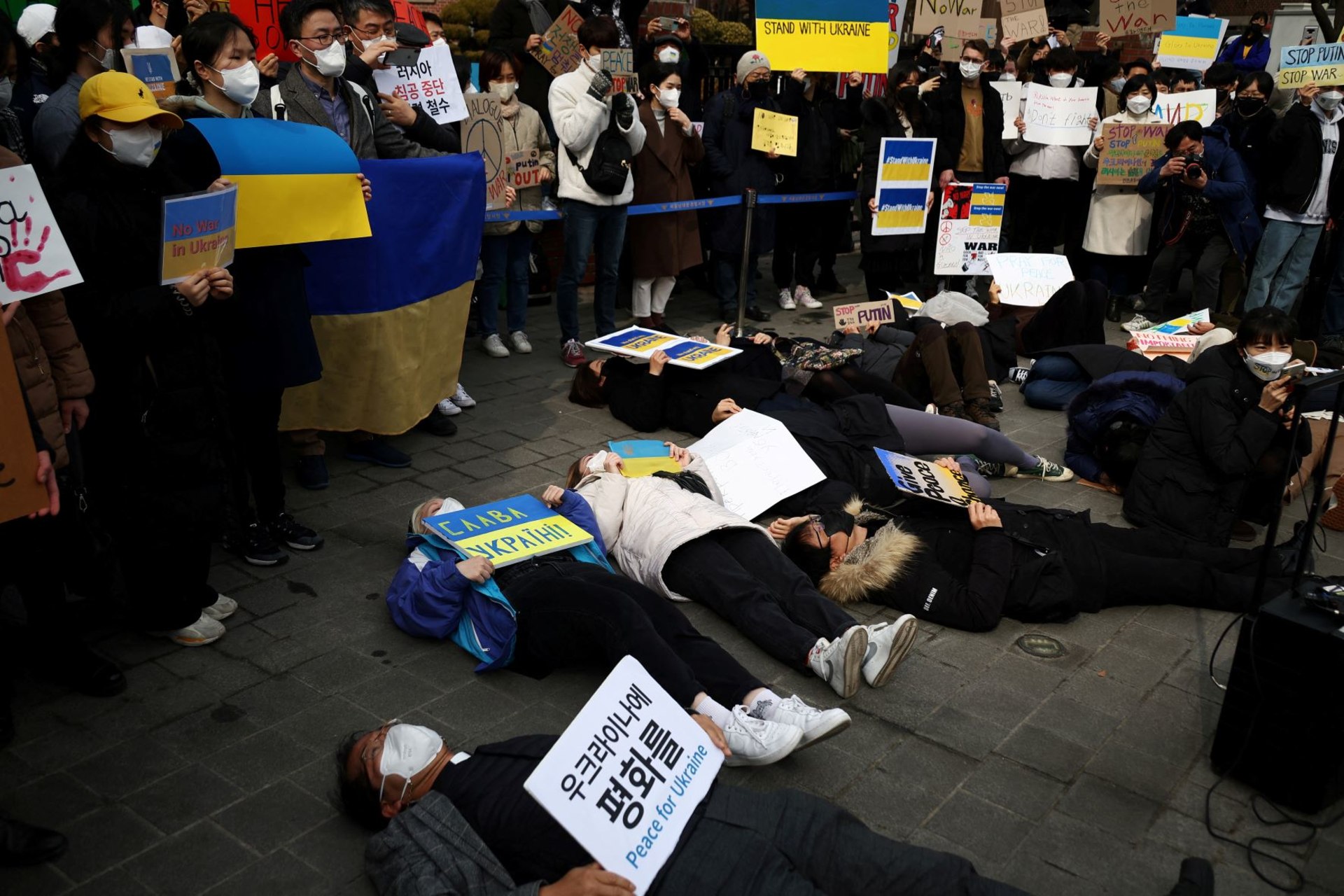 <p>South Korean people lie down on the ground during a protest against the massive military operation by Russia against Ukraine, near the Russian embassy in Seoul, South Korea on February 28, 2022.</p>
