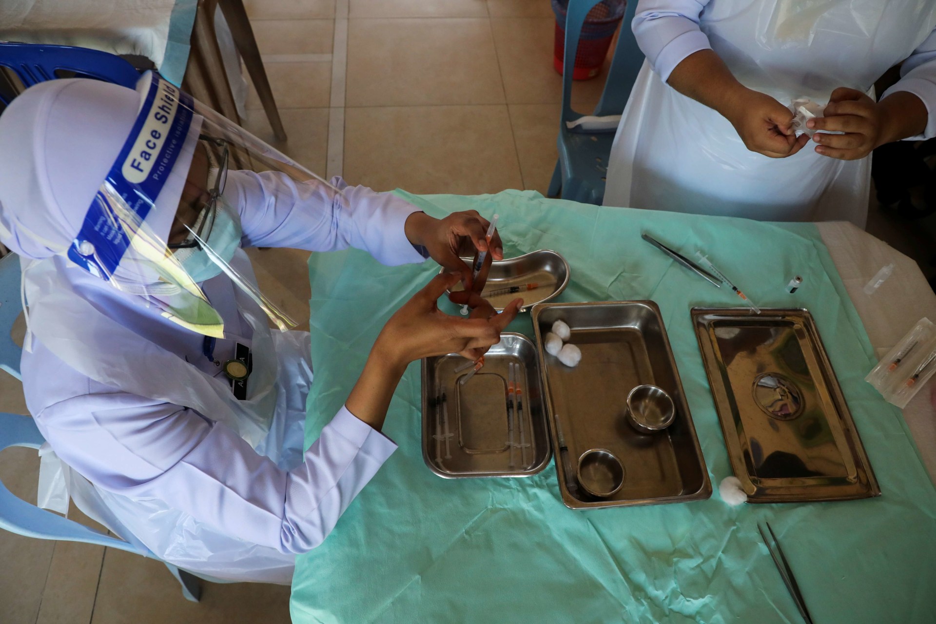 <p>Nurses prepare doses of the Pfizer vaccine against the coronavirus disease (COVID-19) for the secondary school students at a school in Kuala Lumpur, Malaysia, on October 4, 2021.</p>