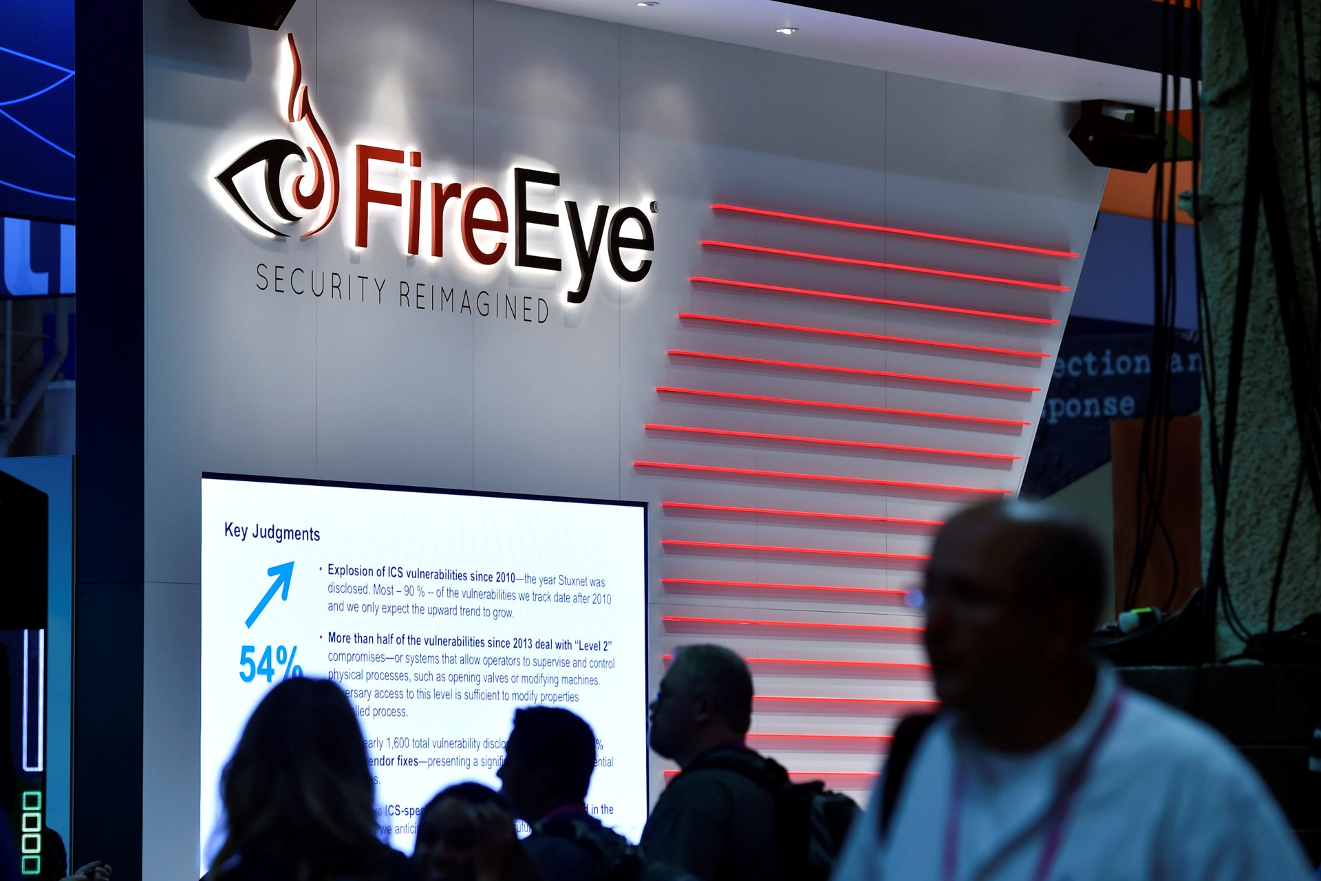 <p>Attendees walk by the FireEye booth during the 2016 Black Hat cyber-security conference in Las Vegas</p>

