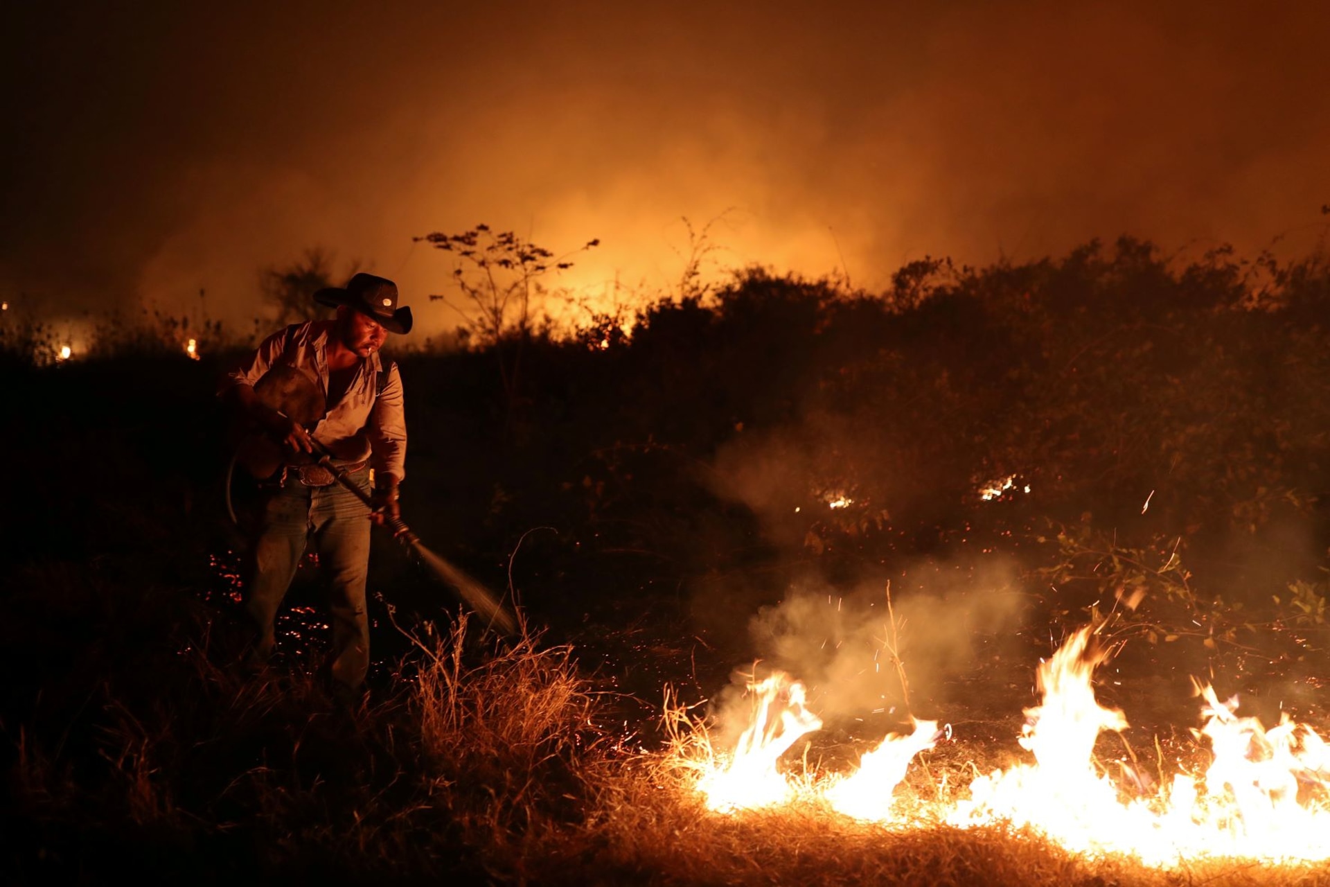 <p>Sebastiao Baldi Silva Junior attempts to put out a fire on a ranch in the Pantanal, the world’s largest wetland, in Pocone, Mato Grosso state in Brazil on August 26, 2020. </p>