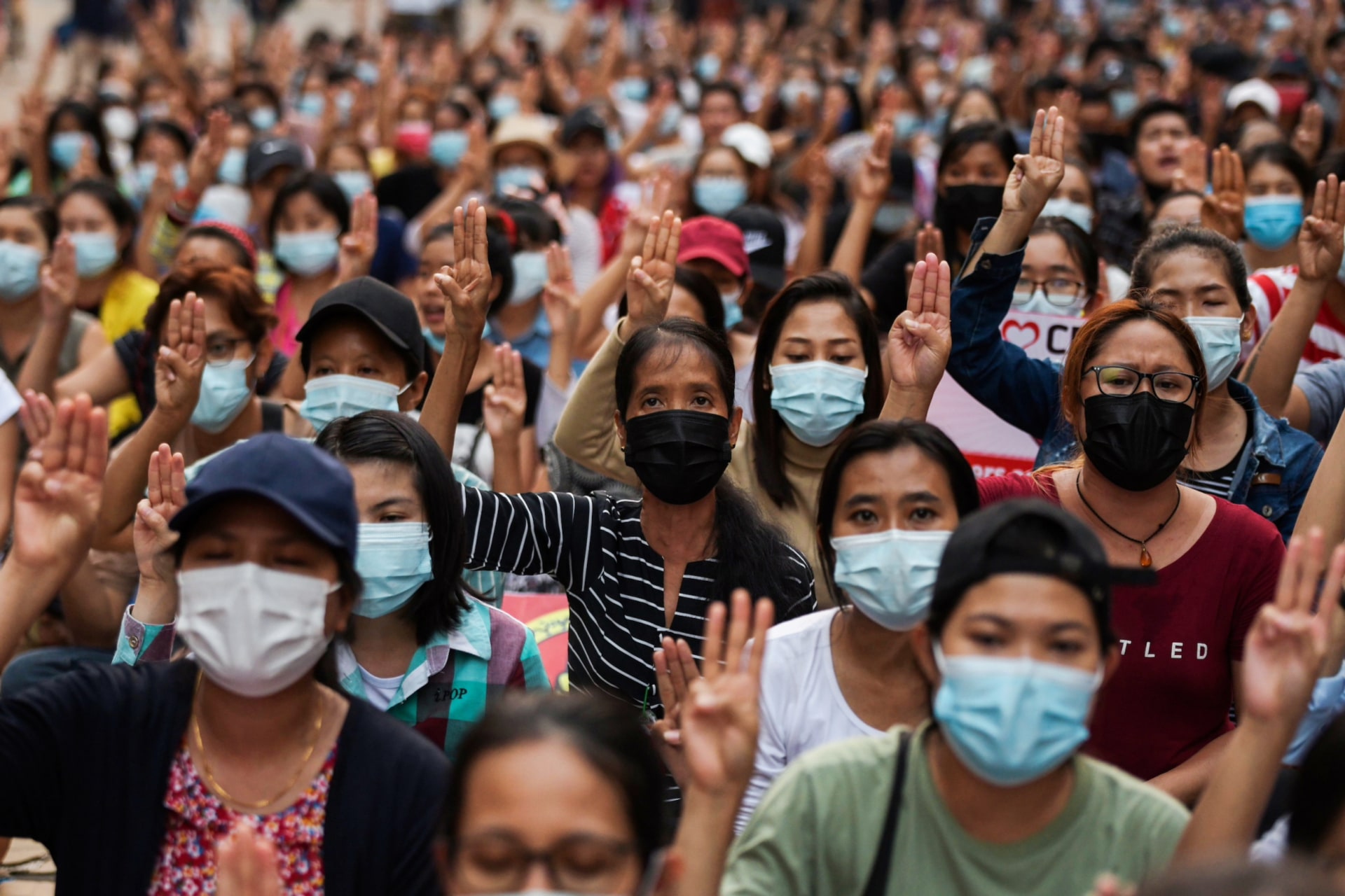 <p>People flash a three-finger salute as they take part in an anti-coup night protest at Hledan junction in Yangon, Myanmar, March 14, 2021.</p>
