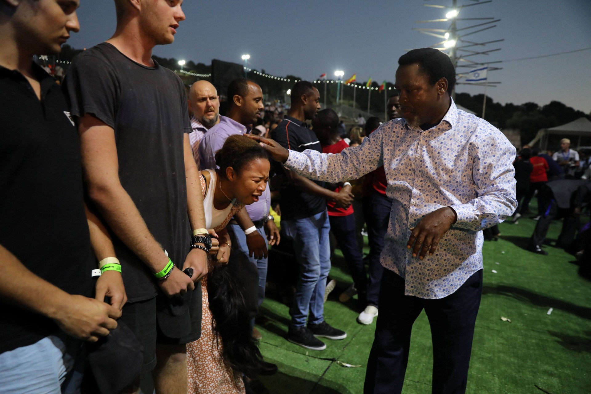 <p>A woman reacts as her head touched by T.B. Joshua, a Nigerian evangelical preacher as he leads a religious retreat on Mount Precipice, Nazareth, northern Israel on June 23, 2019.</p>