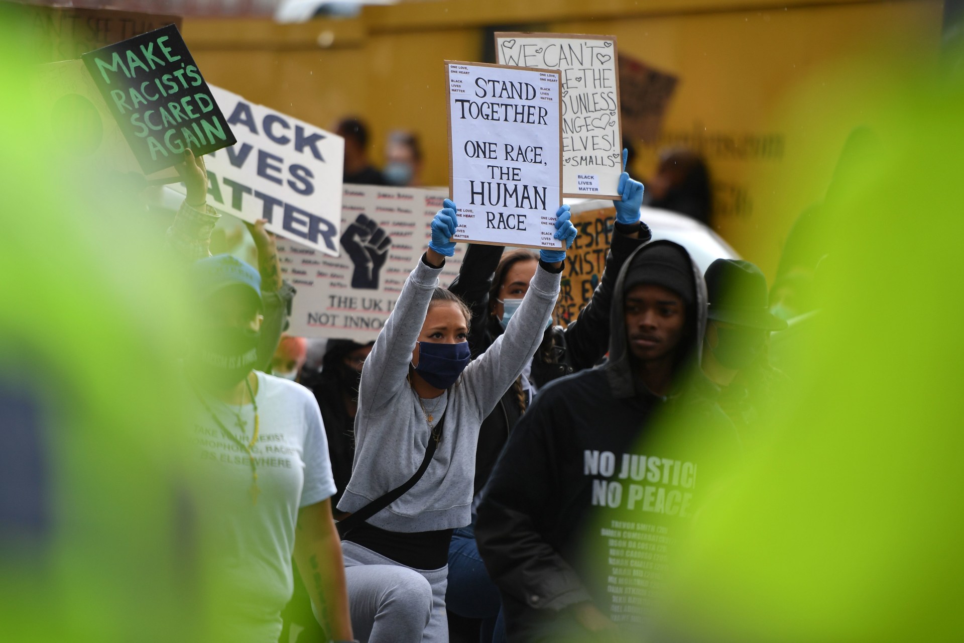 <p>Protesters hold up placards as they “take a knee” in front of a police line at a Black Lives Matter demonstration outside the U.S. Embassy in London on June 7, 2020, during a weekend of global rallies against racism and police brutality. </p>