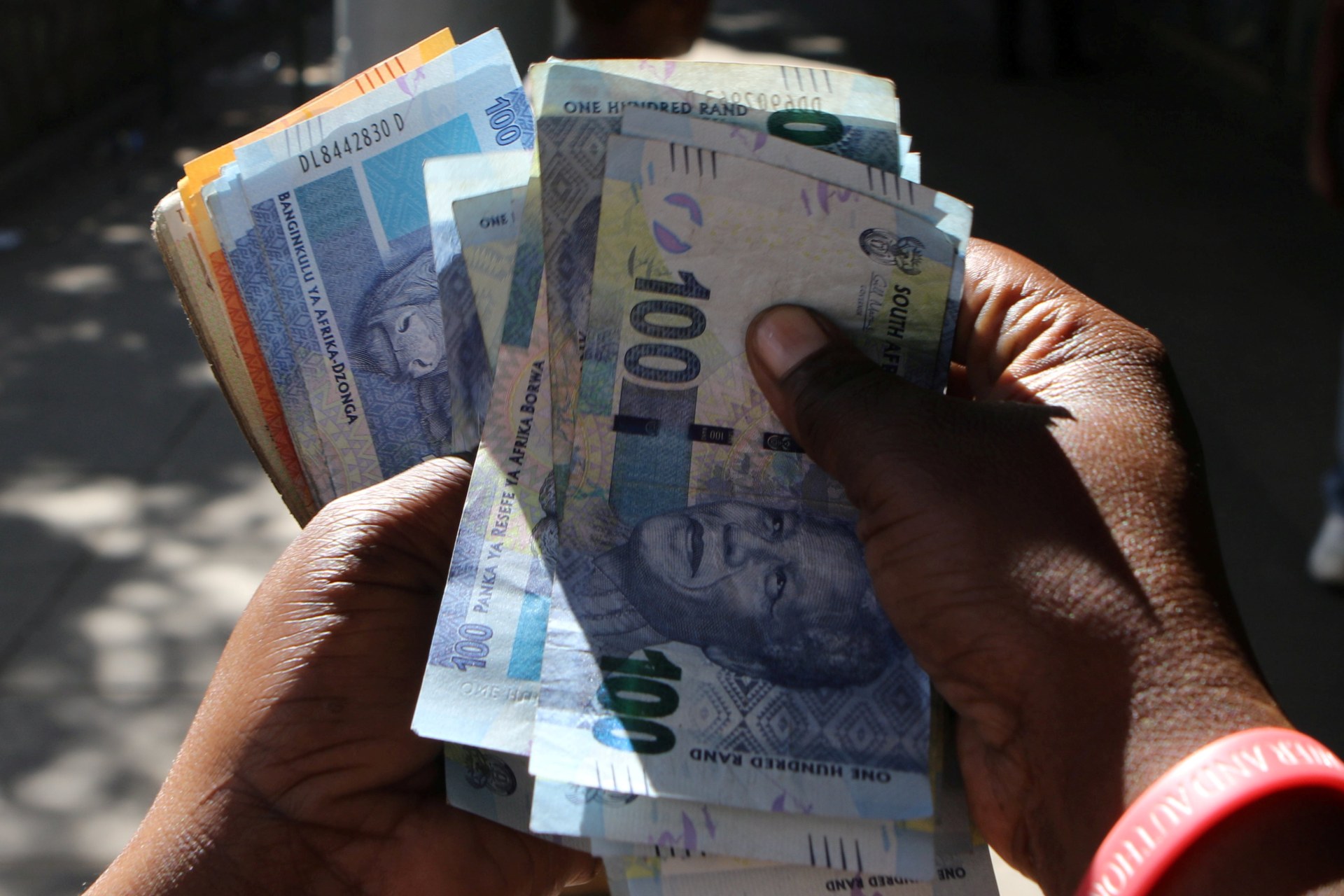 <p>A street money changer counts South African Rands in Harare, Zimbabwe, May 5, 2016</p>