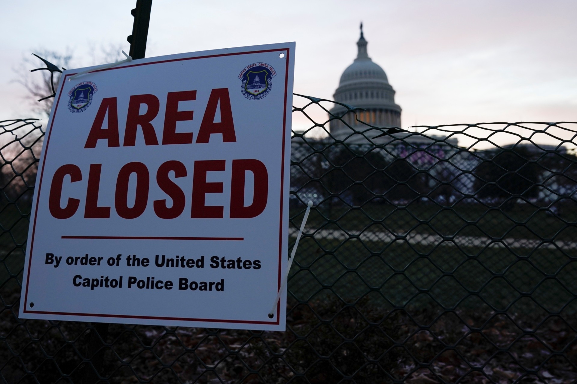 <p>The Capitol is seen behind a fence and a sign, in Washington, D.C. on January 15, 2021.</p>