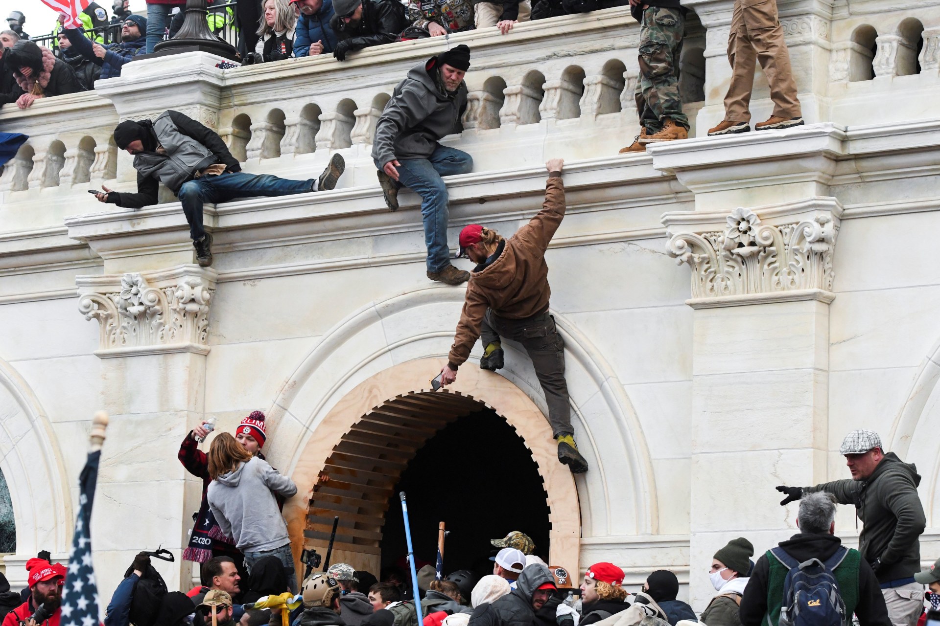 <p>Supporters of U.S. President Donald Trump climb on walls at the U.S. Capitol.</p>