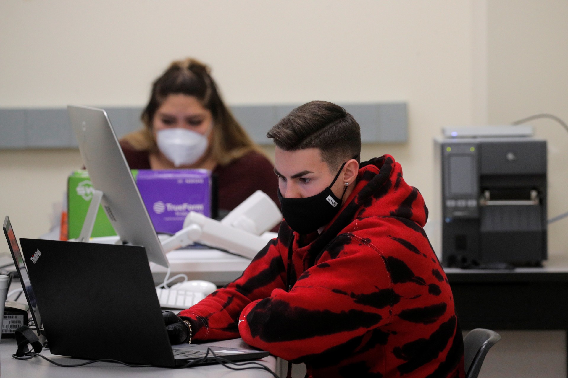 <p>health care workers run coronavirus tests in a lab at a COVID drive-thru testing center.</p>