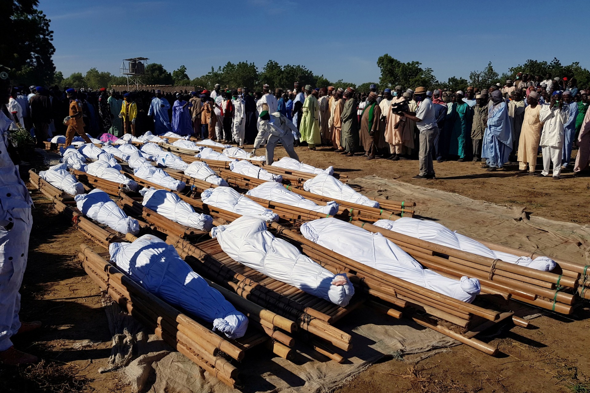<p>Men gather near dead bodies of people who were killed by militant attack, during a mass burial at Zabarmari, in the Jere local government area of Borno State, in northeast Nigeria, on November 29, 2020.</p>
