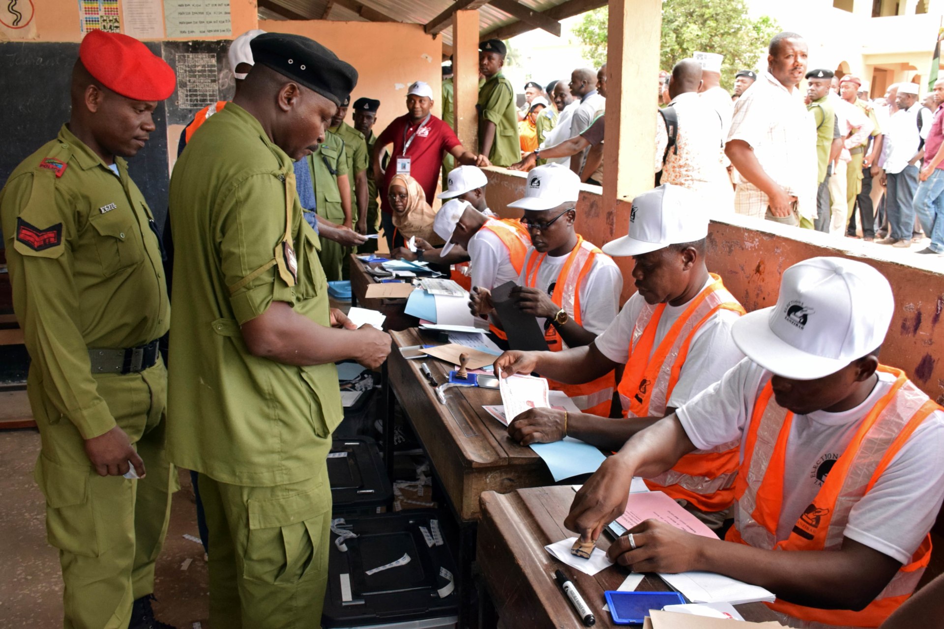 <p>Tanzanian government officials are processed before casting their ballots at a polling centre during the early voting for essential workers at the presidential and parliamentary polls in the semi-autonomous island of Zanzibar, Tanzania October 27, 2020</p>