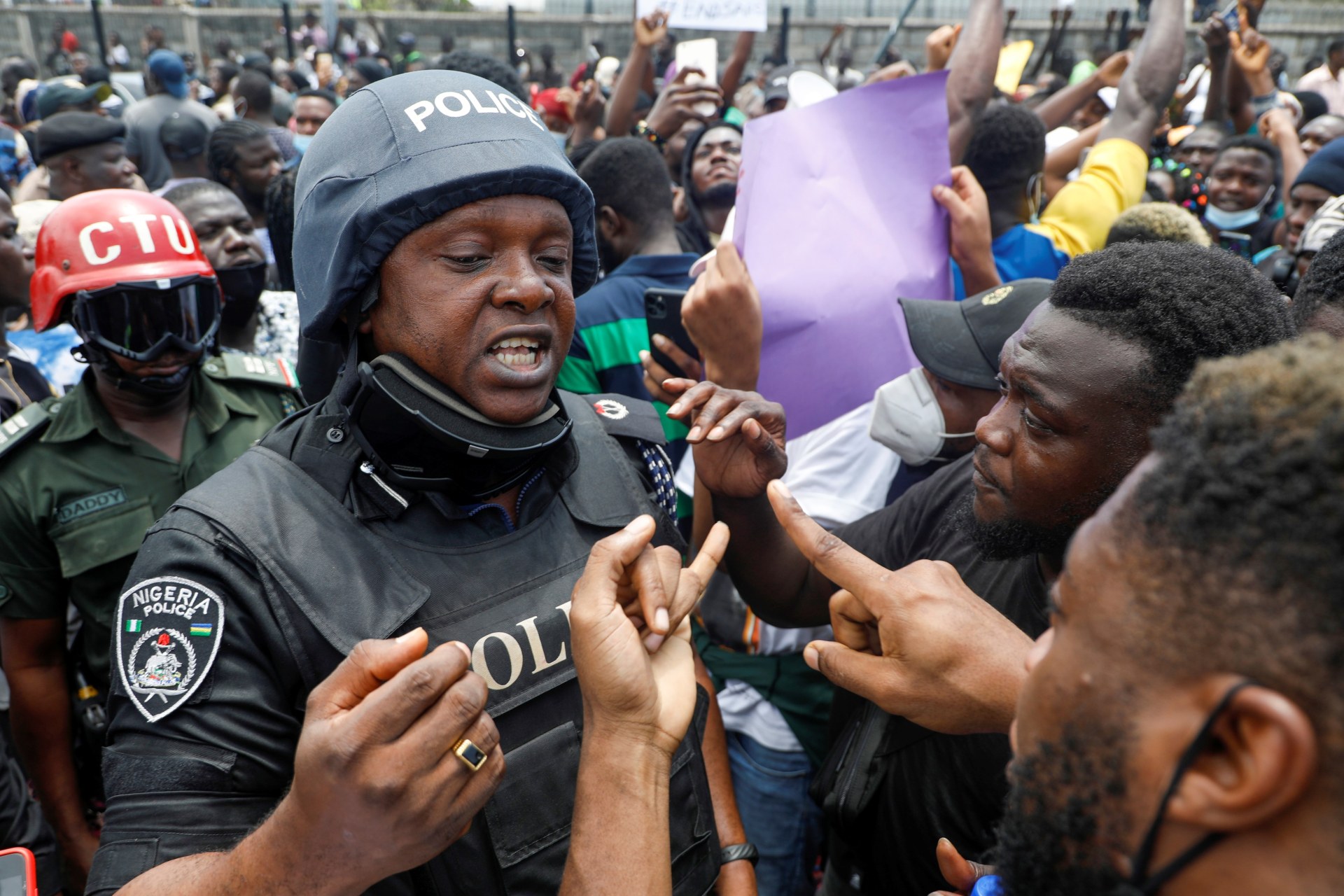 <p>Demonstrators talk to a police officer during a protest over alleged police brutality, in Lagos, Nigeria on October 12, 2020.</p>
