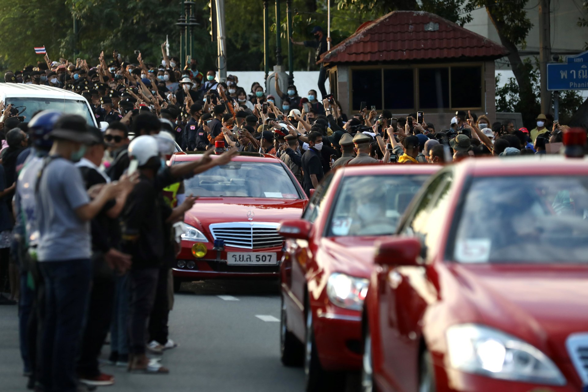 <p>Pro-democracy demonstrators flash a three-finger salute as a royal motorcade drives past during a Thai antigovernment mass protest, on the 47th anniversary of the 1973 student uprising, in Bangkok, Thailand on October 14, 2020. </p>