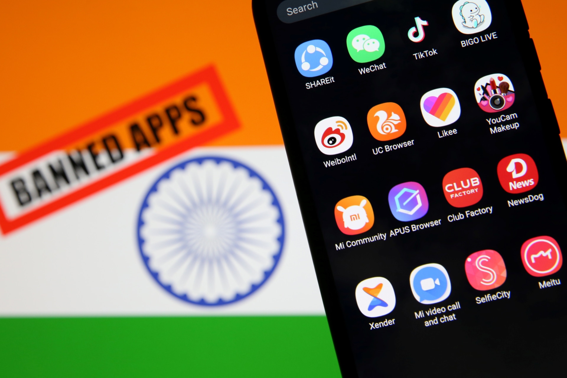 <p>Smartphone with Chinese applications is seen in front of a displayed Indian flag and a “Banned app” sign.</p>
