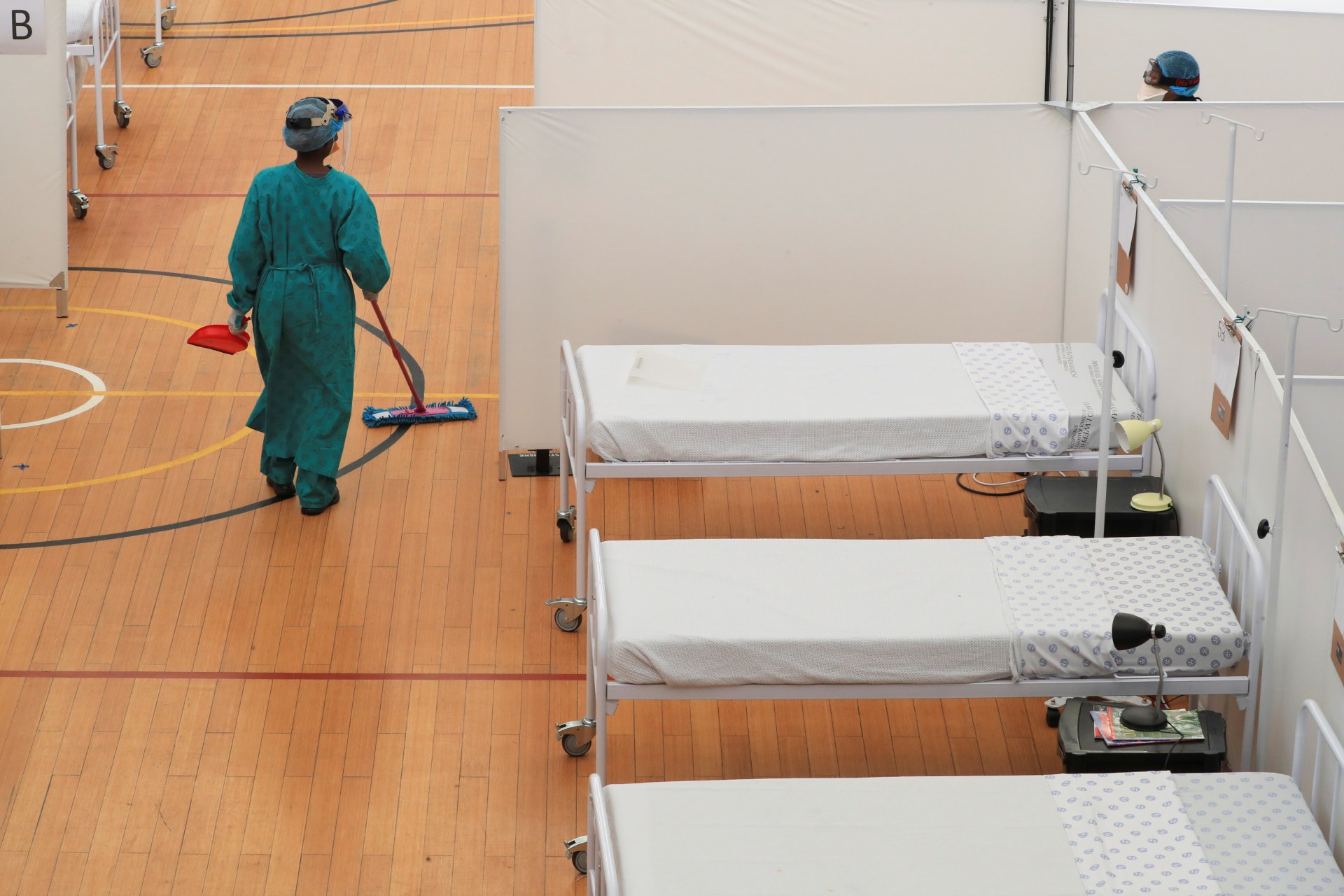 <p>A health worker walks between beds at a temporary field hospital set up in a sports complex by Medecins Sans Frontieres (MSF) during the coronavirus disease (COVID-19) outbreak in Khayelitsha township near Cape Town, South Africa, on July 21, 2020.</p>