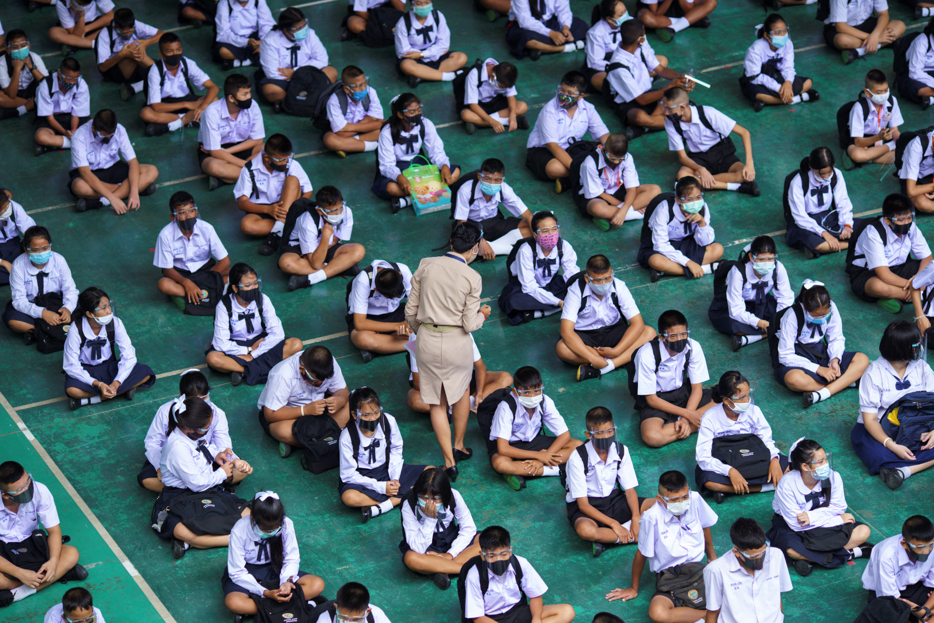 <p>Students wearing face masks and face shields sit as they attend a flag-raising ceremony as schools nationwide reopened, in Pathum Thani province, Thailand on July 1, 2020.</p>