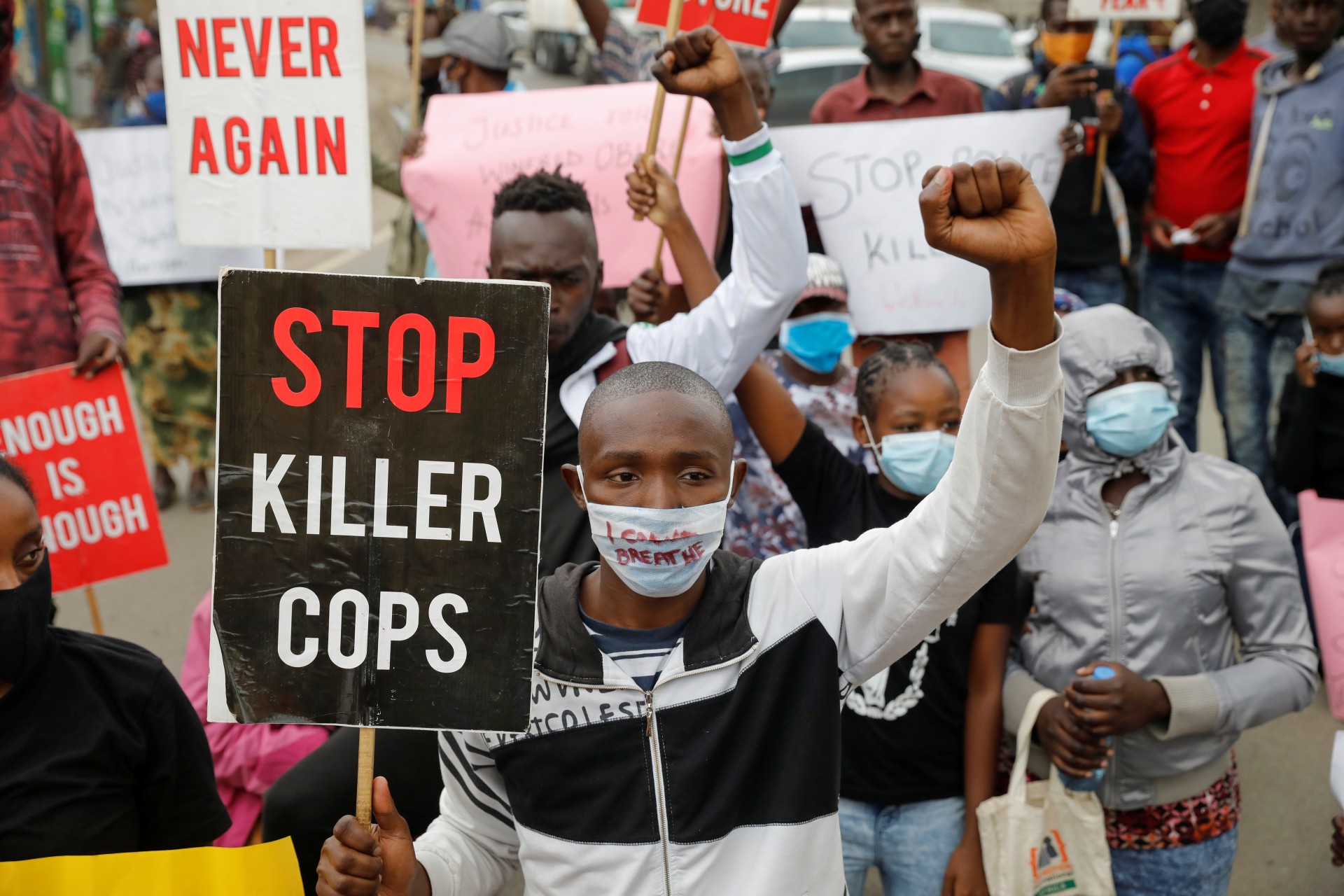 <p>Protesters hold signs and placards during a demonstration against police killings and brutality, in the Mathare slum in Nairobi, Kenya, June 8, 2020. </p>