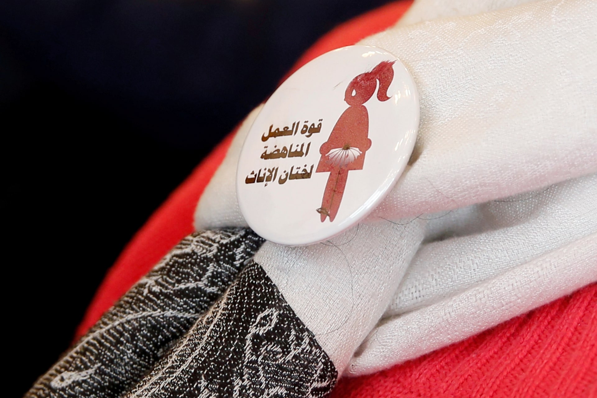 <p>A volunteer at a conference on International Day of Zero Tolerance for Female Genital Mutilation (FGM) in Cairo, Egypt, wears a badge that reads “The power of labor against FGM.” February 6, 2018.</p>
