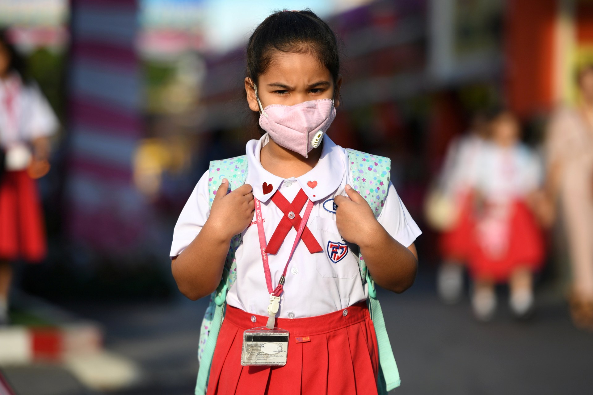 <p>A girl arrives to school wearing a protective mask in Ayutthaya, outside Bangkok, Thailand February, 2020.</p>
