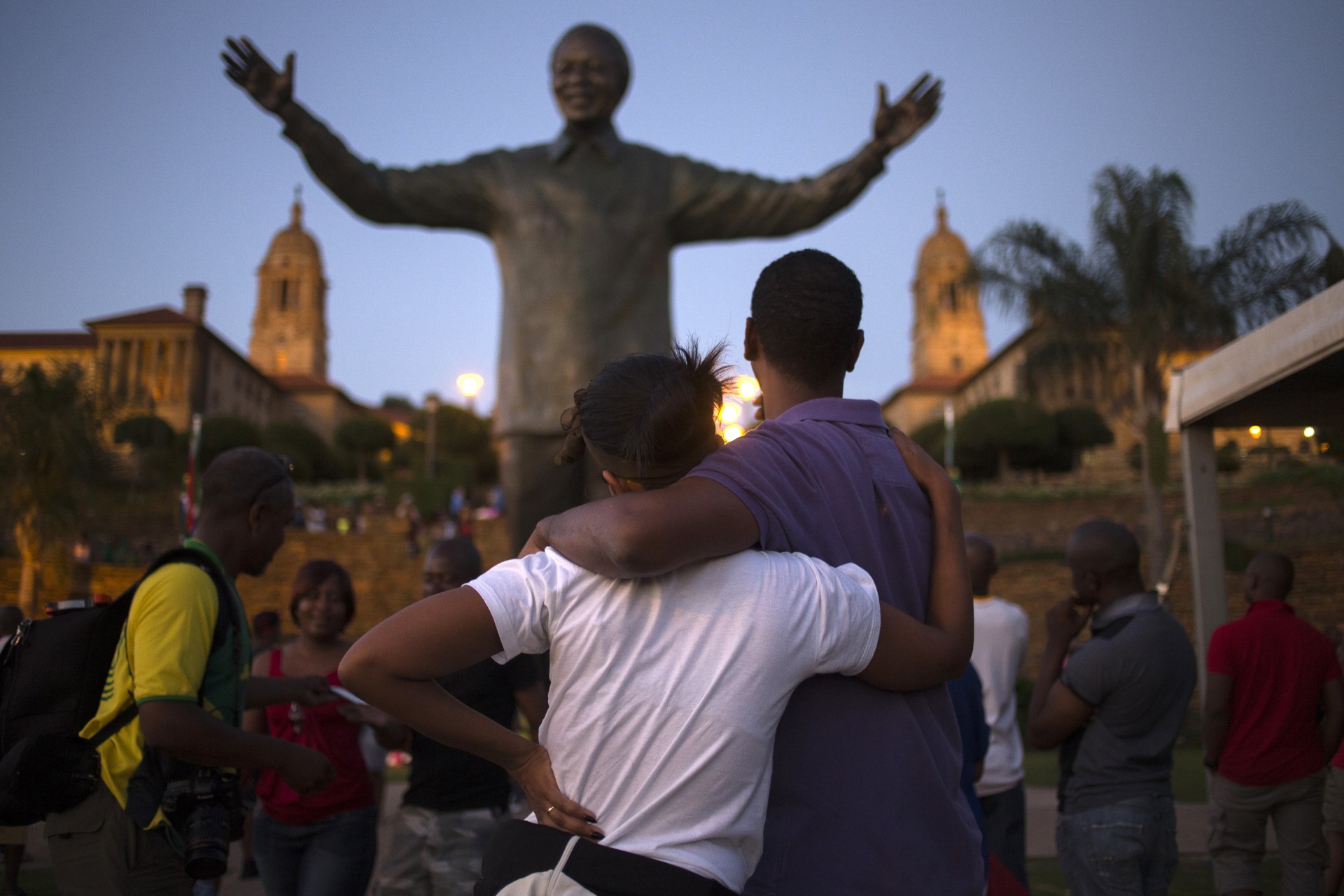 <p>A couple stands near a bronze statue of late former South African President Nelson Mandela hours after it was unveiled as part of Day of Reconciliation celebrations at the Union Buildings in Pretoria, on December 16, 2013.</p>