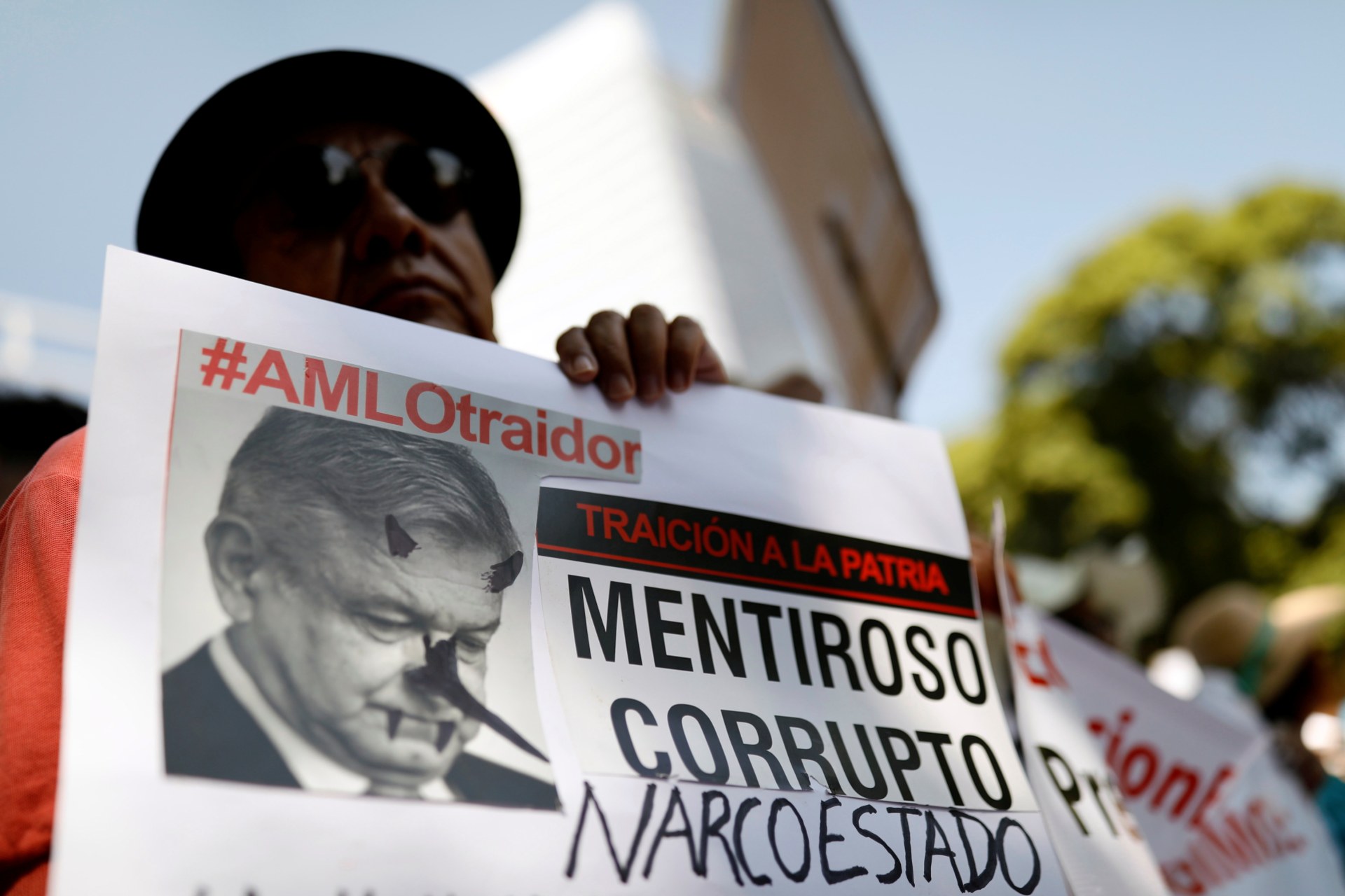 <p>A demonstrator holds a sign during a march against Mexico’s president Andres Manuel Lopez Obrador as he delivers his first state of the union in Mexico City, Mexico, September 1, 2019. The sign reads, “#AMLO traitor. Liar. Corrupt. Narco-state”.</p>