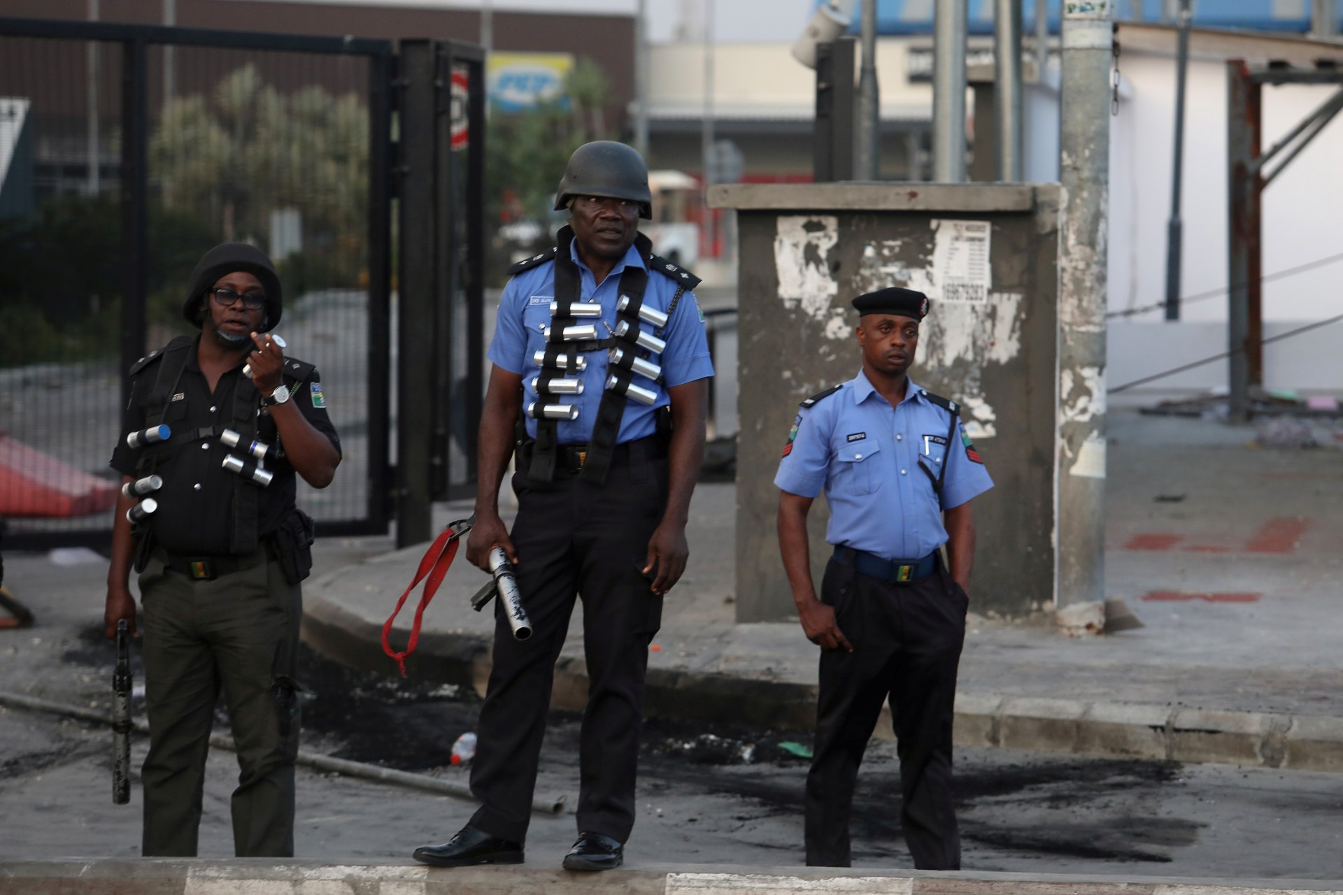 <p>Three armed police officers stand in front of the Novare Shoprite Mall in Lekki, near Lagos, Nigeria, after it was looted, on September 3, 2019.</p>
