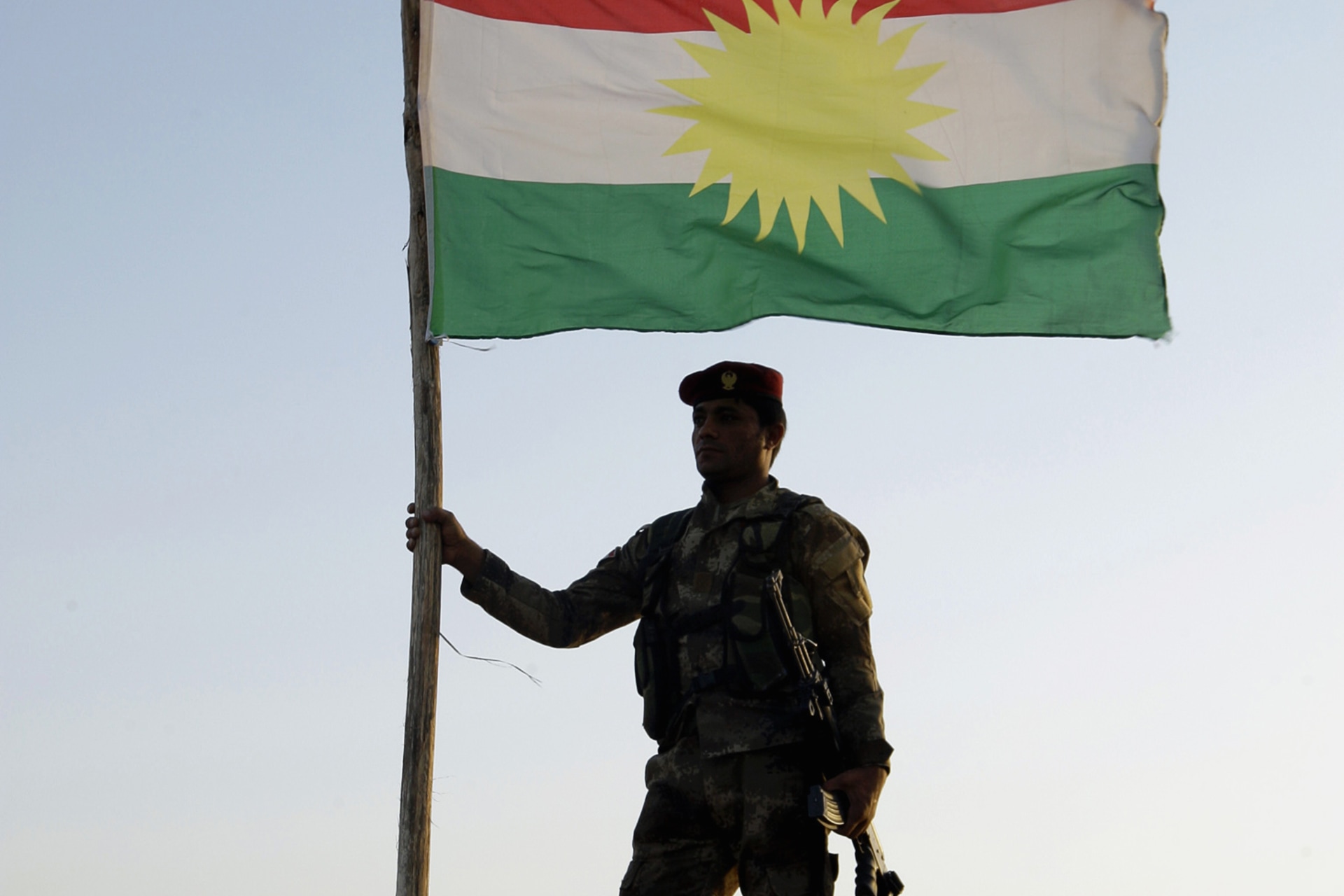 <p>A Kurdish Peshmerga soldier holds a Kurdistan flag during a deployment in the area near the northern Iraqi border with Syria</p>
