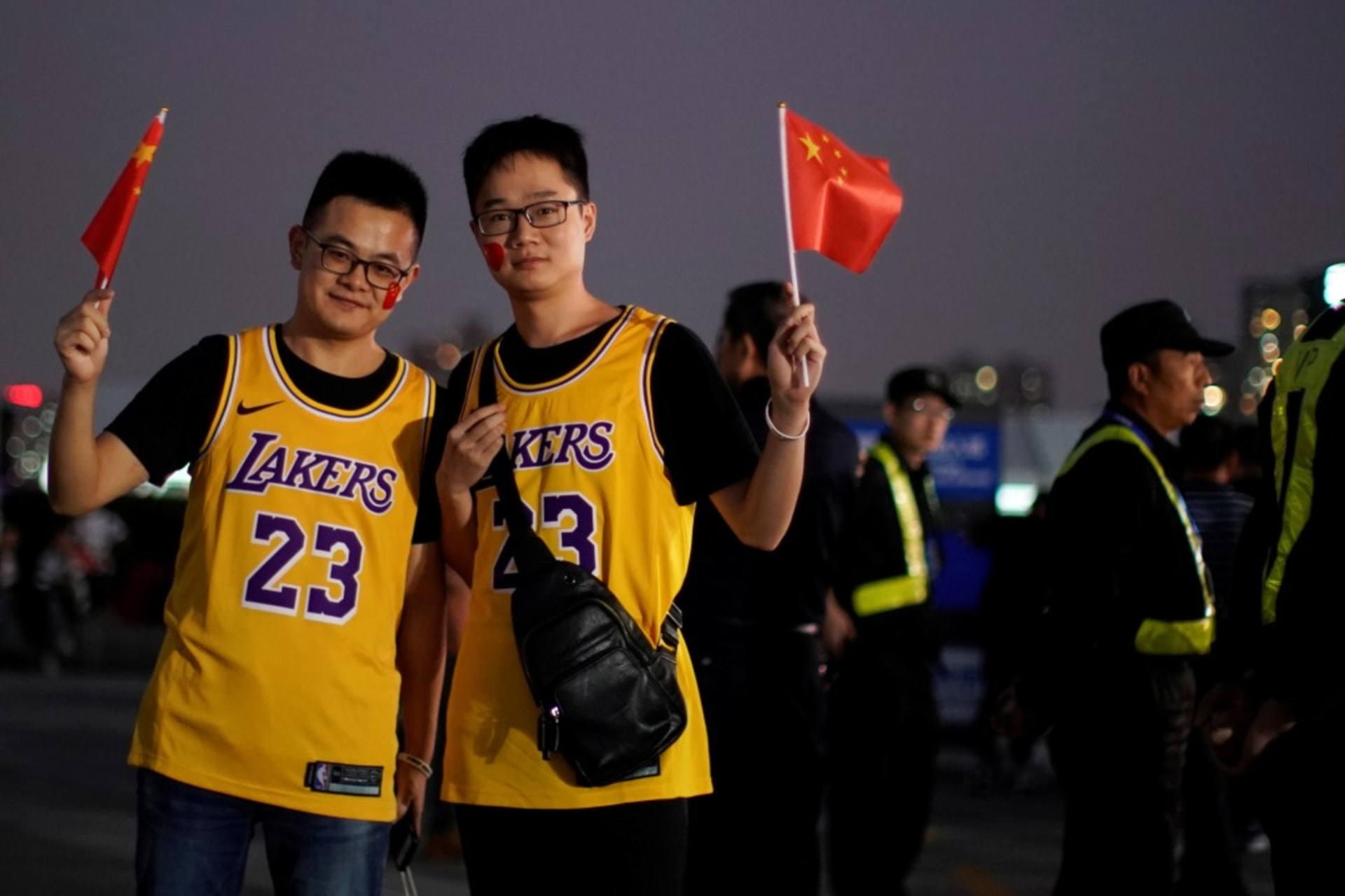 <p>Fans in LeBron James jerseys pose for pictures with Chinese flags near security personnel outside the Mercedes-Benz Arena before the NBA exhibition game between Brooklyn Nets and Los Angeles Lakers in Shanghai, October 10, 2019.</p>