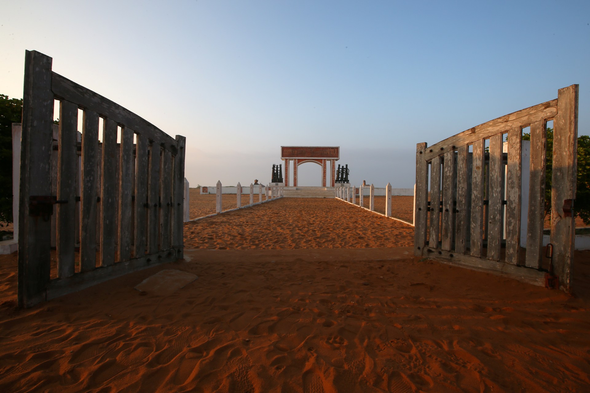 <p>Open gates are seen before a monument at the site of the “Point of No Return” where slaves were loaded onto ships in the historic slave port of Ouidah, Benin, on July 17, 2019. </p>