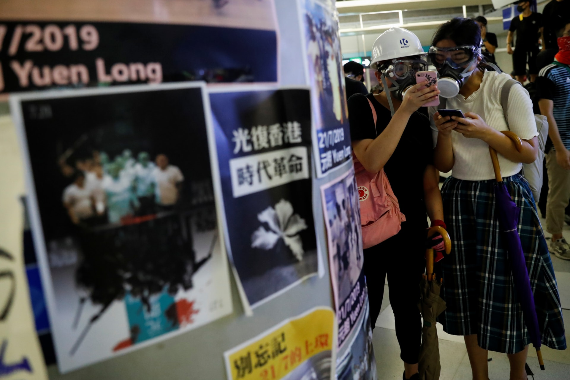 <p>Protesters check their phones as they take part in a protest inside the Yuen Long MTR station. Hong Kong, China. August 21, 2019.</p>
