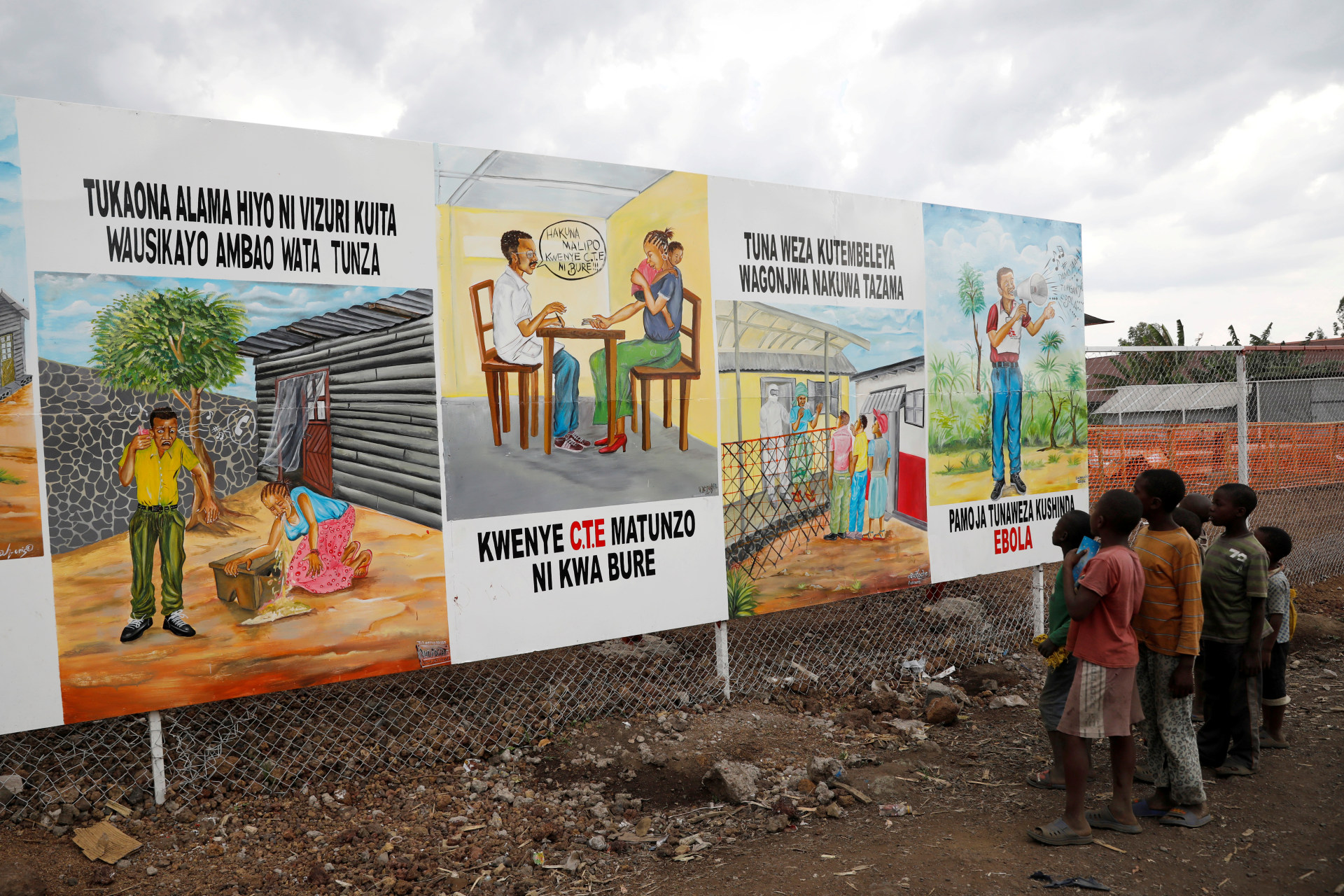 <p>Children look at a billboard providing information about Ebola outside the newly constructed MSF (Doctors Without Borders) Ebola treatment centre in Goma in Democratic Republic of Congo, August 3, 2019.</p>

