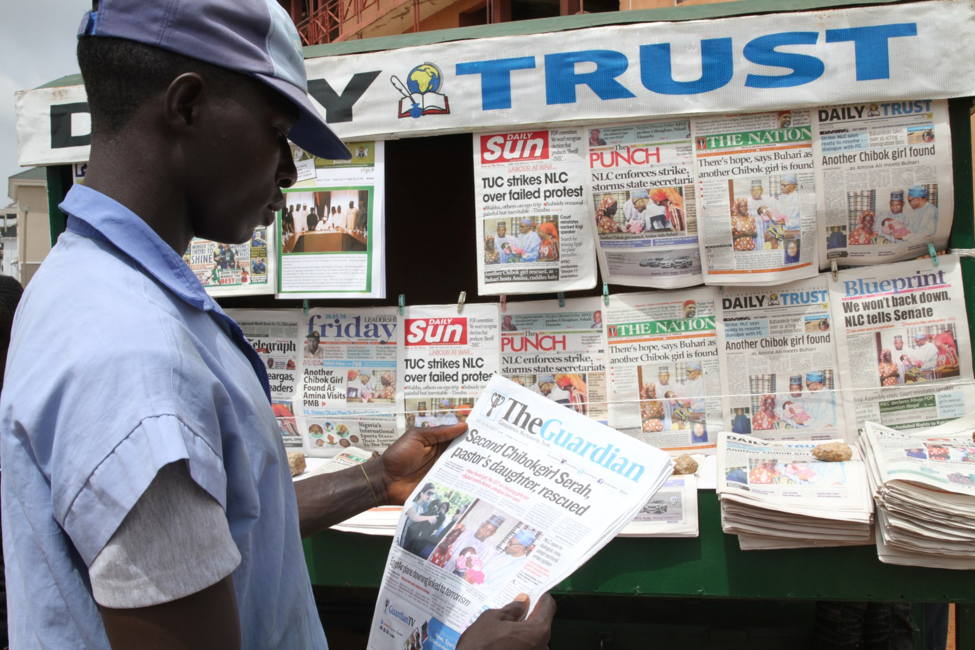<p>A man looks at a newspaper headline in Abuja, Nigeria, on May 20, 2016.</p>
