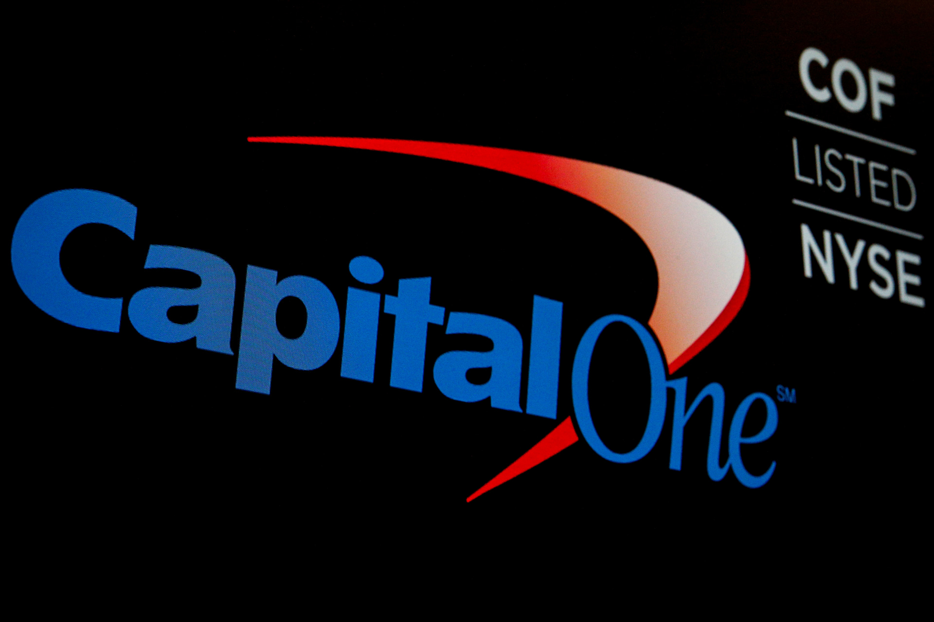 <p>The logo and ticker for Capital One are displayed on a screen on the floor of the NYSE in New York</p>

