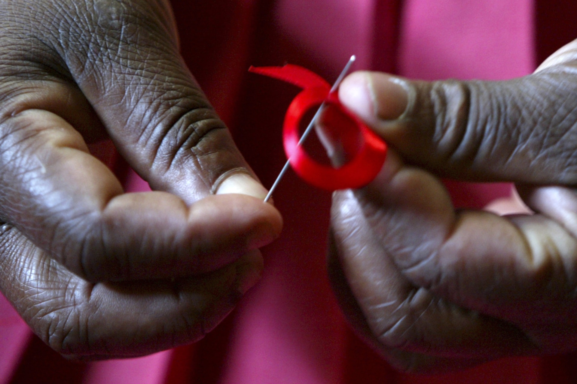 <p>A Kenyan woman prepares a ribbon in honor of World AIDS Day in Nairobi, Kenya on November 25, 2004</p>
