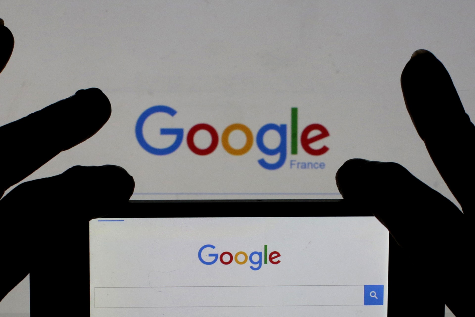 <p>A woman holds her smart phone which displays the Google home page, France.</p>
