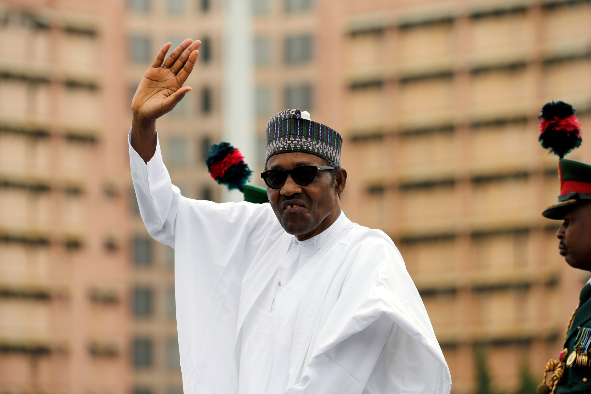 <p>Nigerian President Muhammadu Buhari waves at the crowd while he drives around the venue during his inauguration for a second term in Abuja, Nigeria, on May 29, 2019.</p>