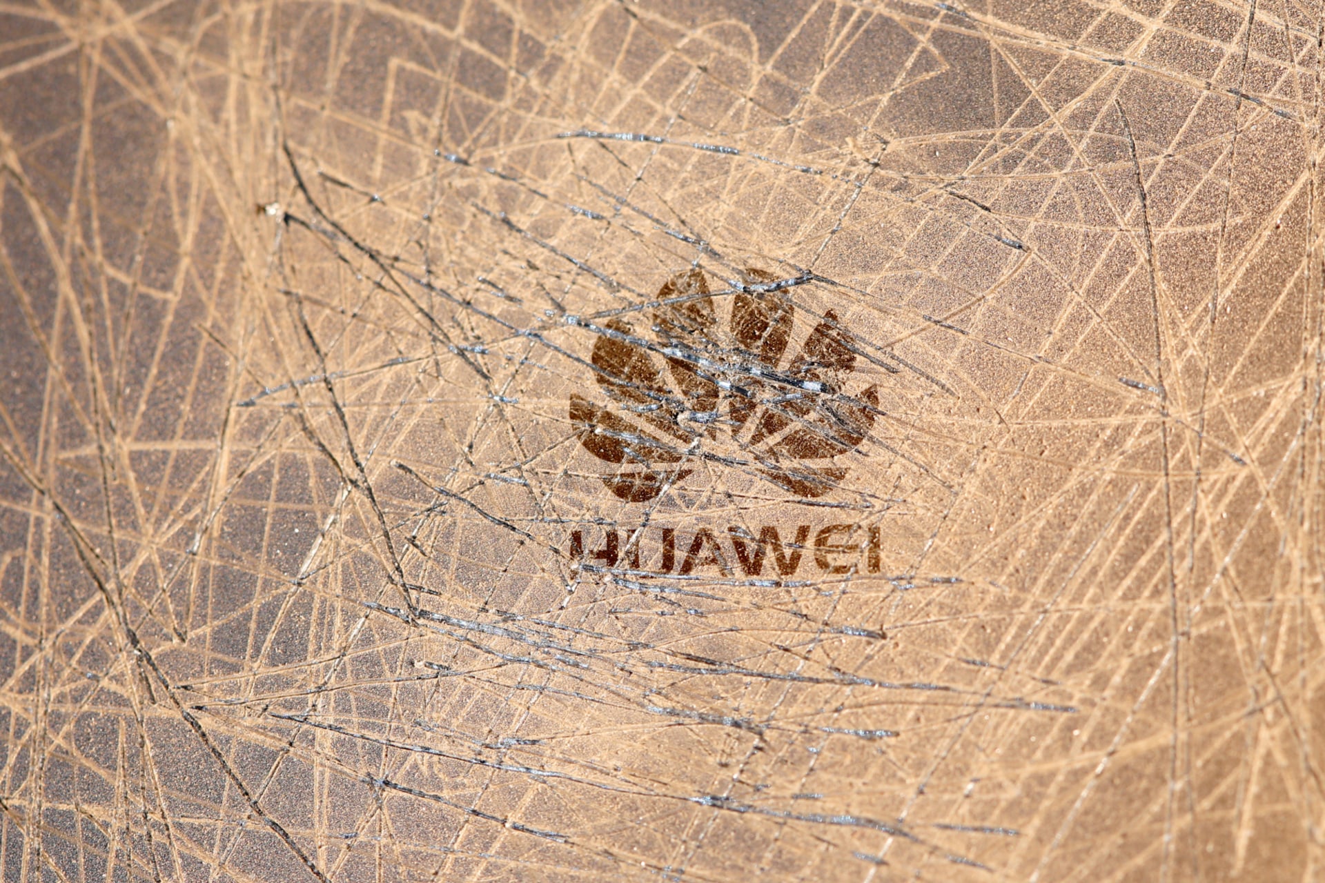 <p>A scratched surface Huawei logo is seen on a smarthphone in this illustration picture </p>

